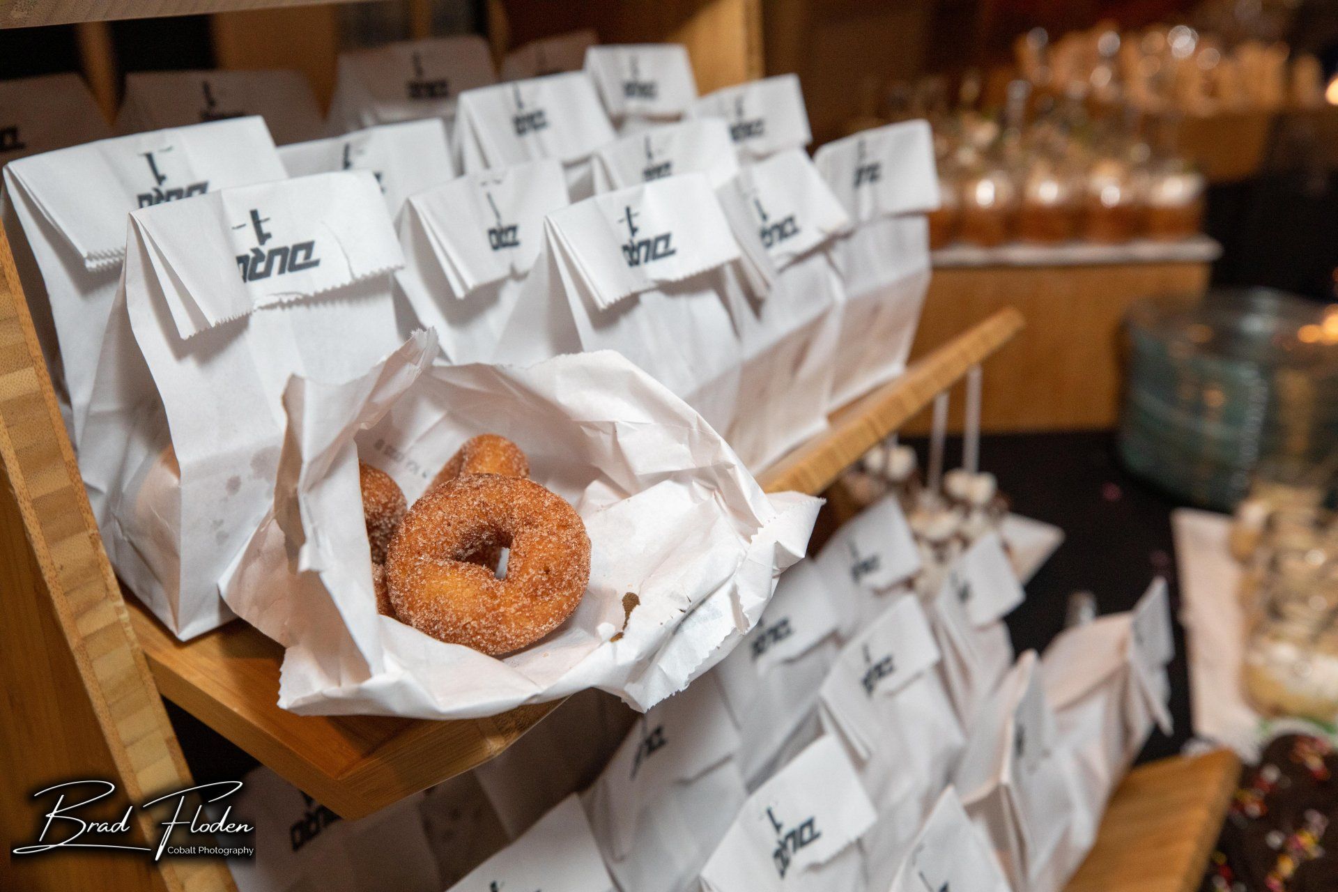 A cinnamon donut is in a paper bag on a table.