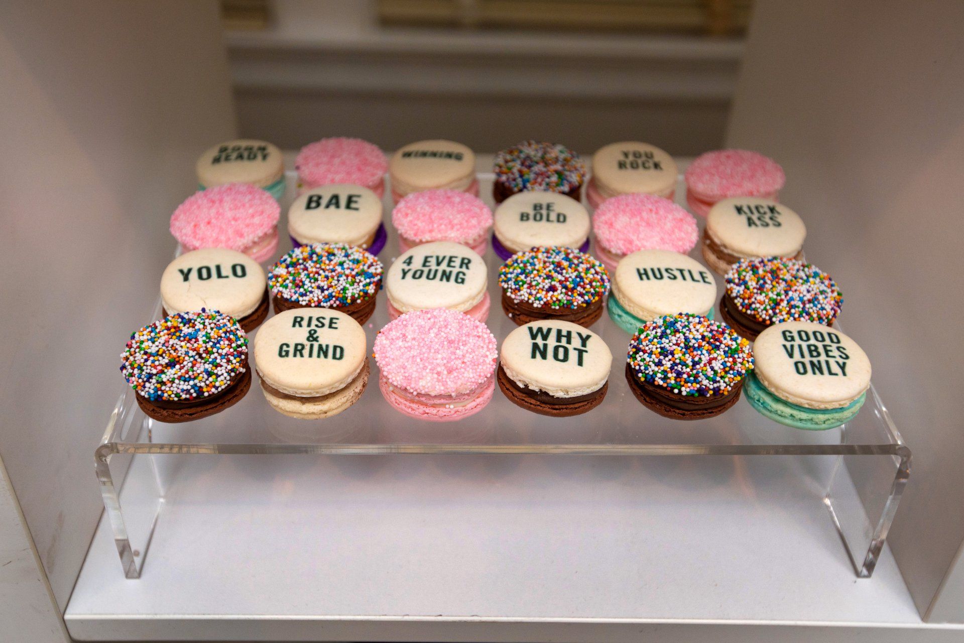 A bunch of cookies with sprinkles on them on a shelf