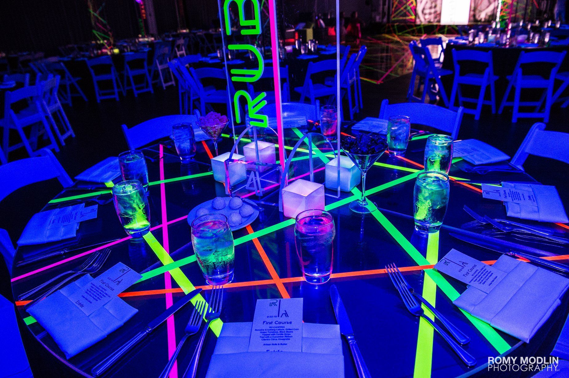 A table set for a party with glow in the dark decorations.