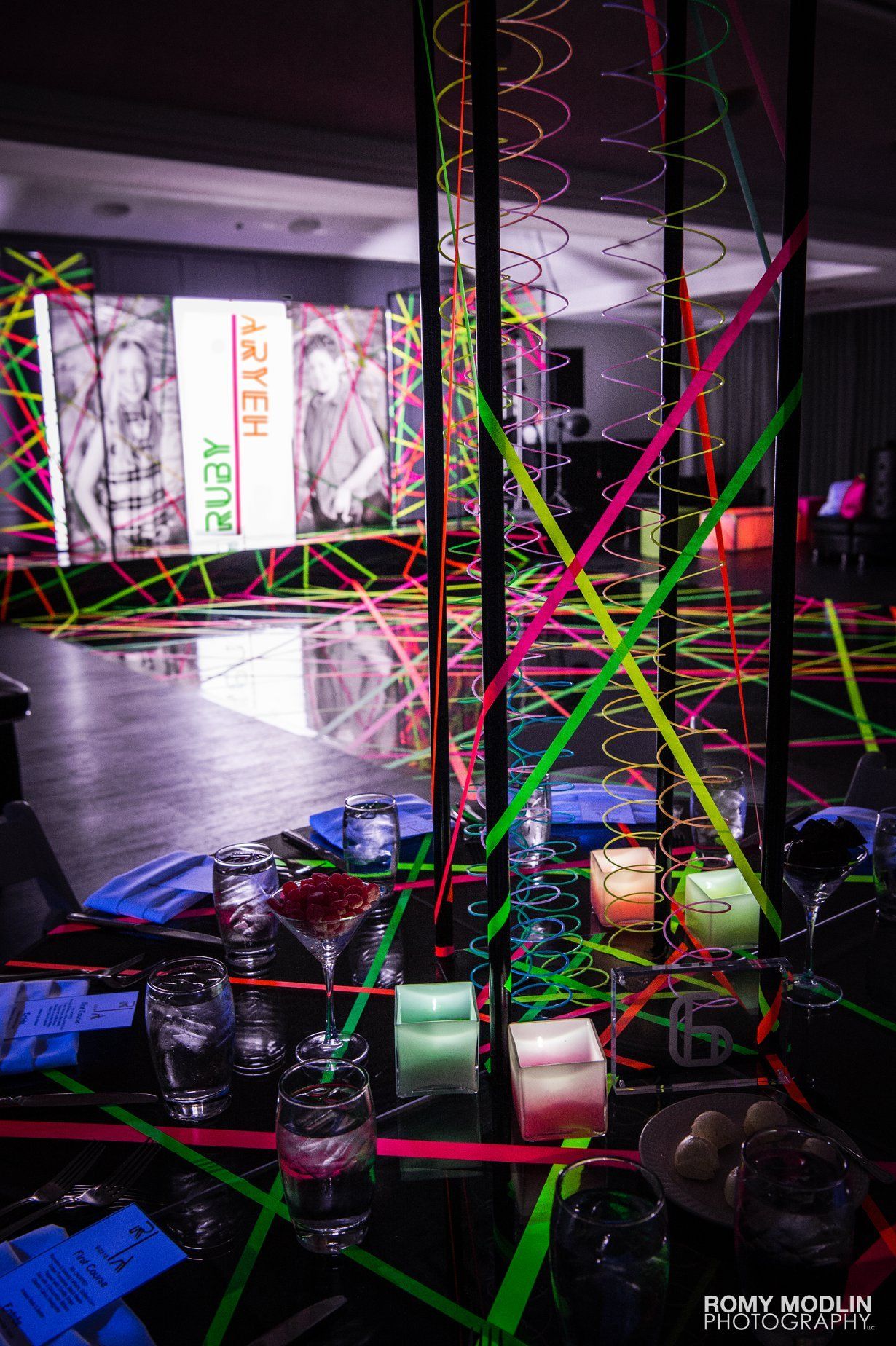 A room decorated with neon tape and candles for a party.