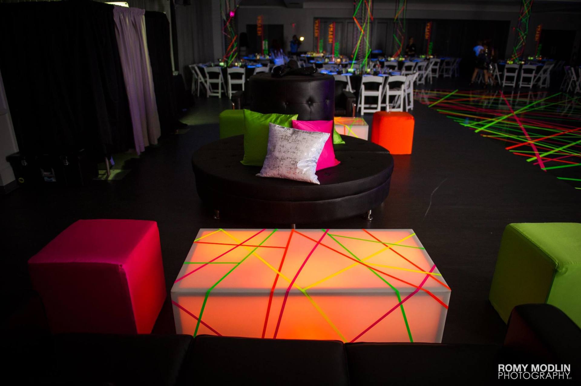 A glow in the dark room with tables and chairs