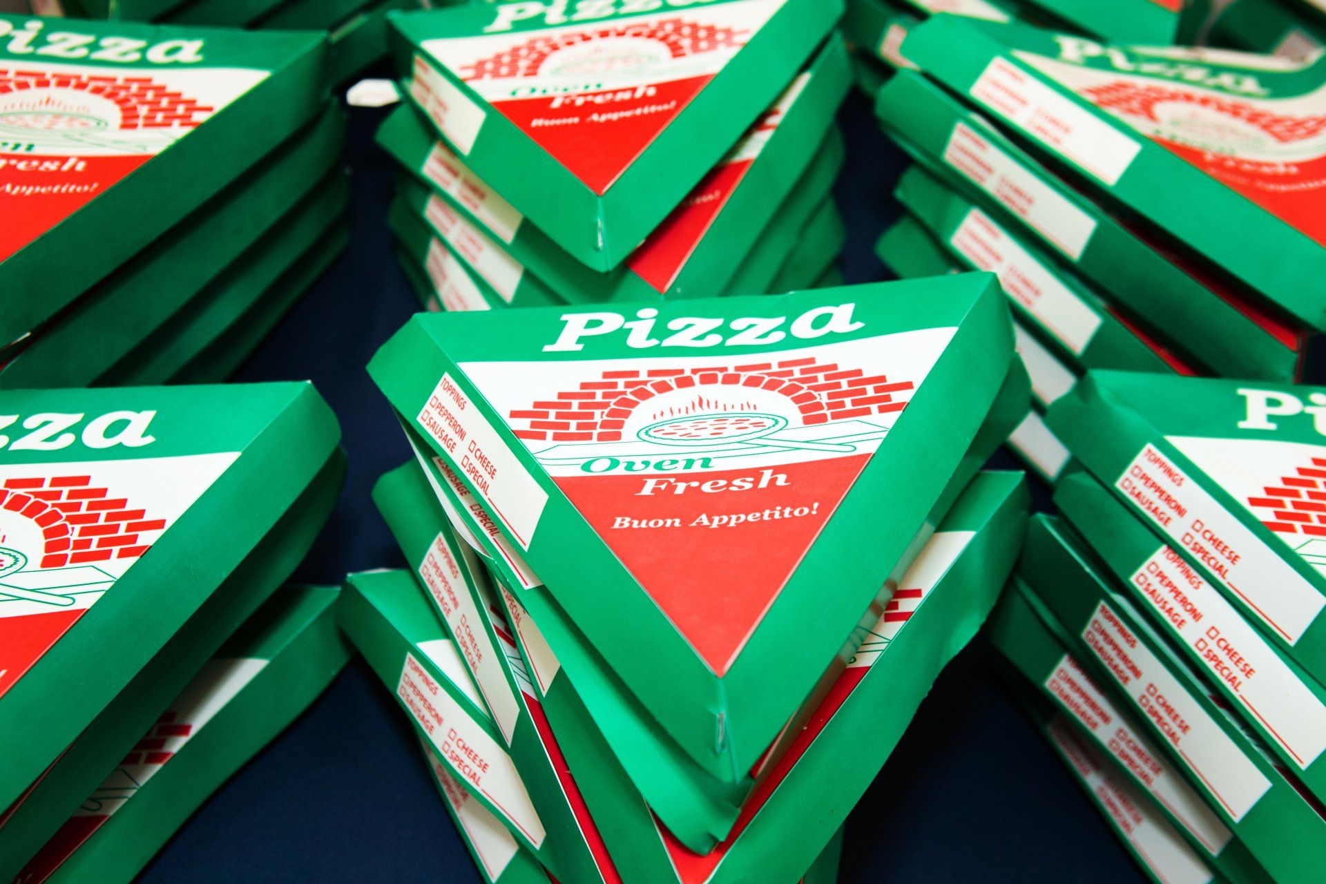A bunch of pizza boxes stacked on top of each other