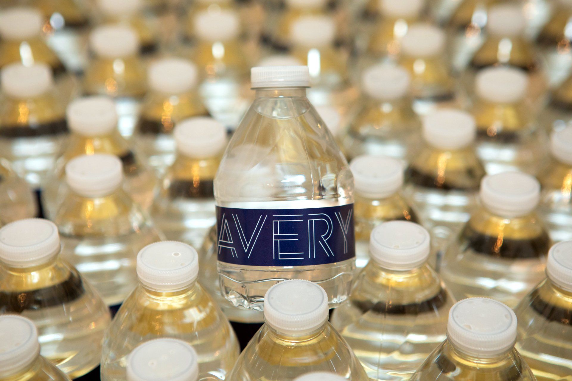 A bottle of avery water is surrounded by many other bottles of water.