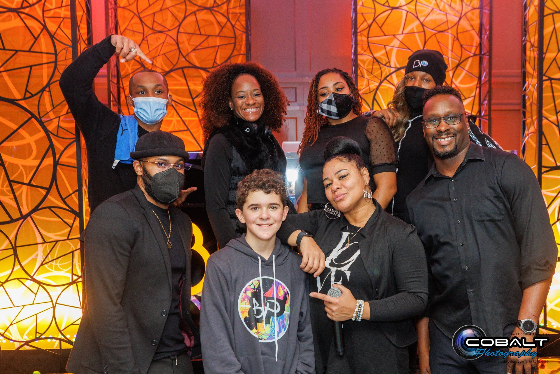 A group of people wearing face masks are posing for a picture.
