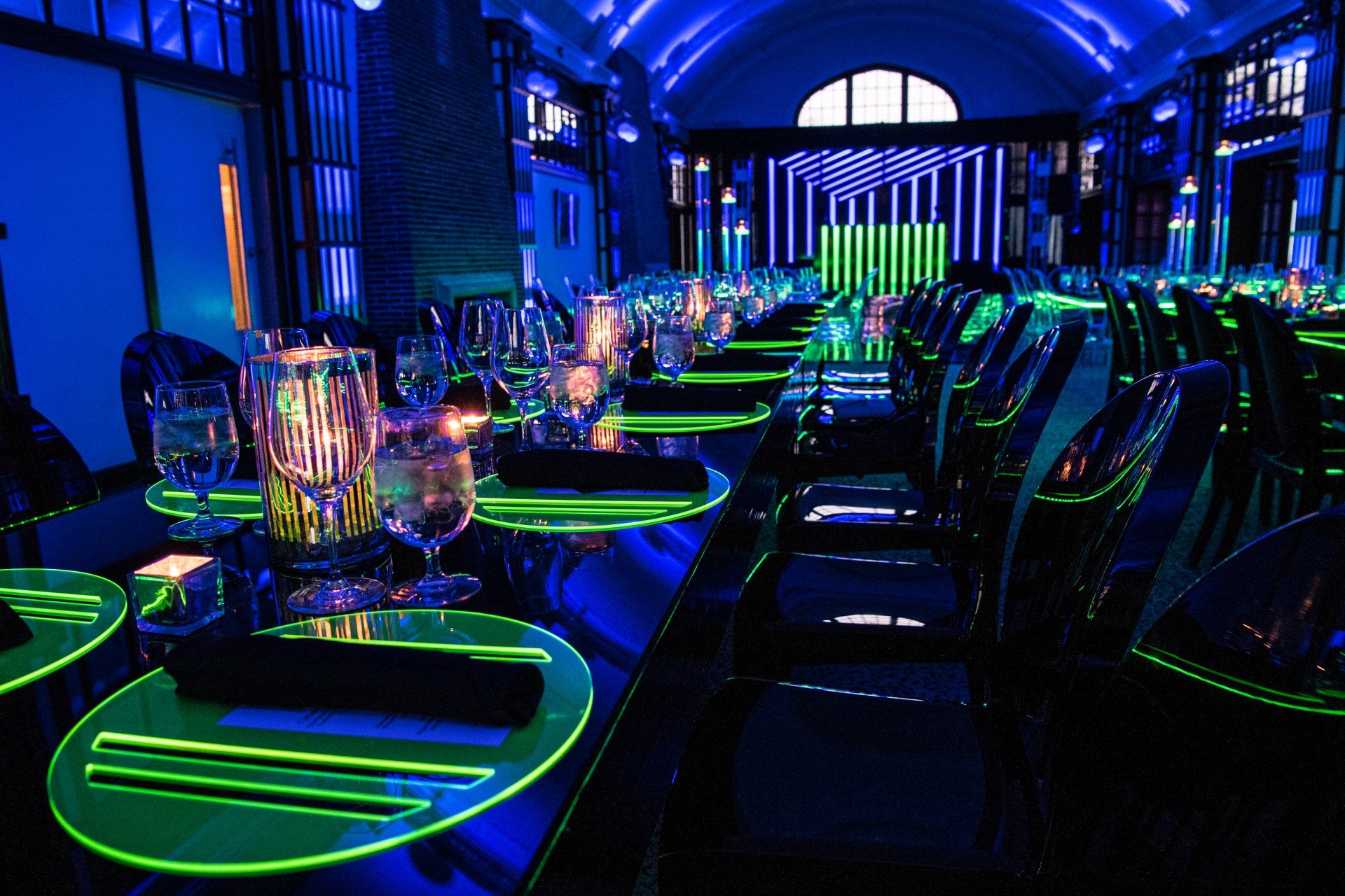 A long dining room with glow in the dark tables and chairs