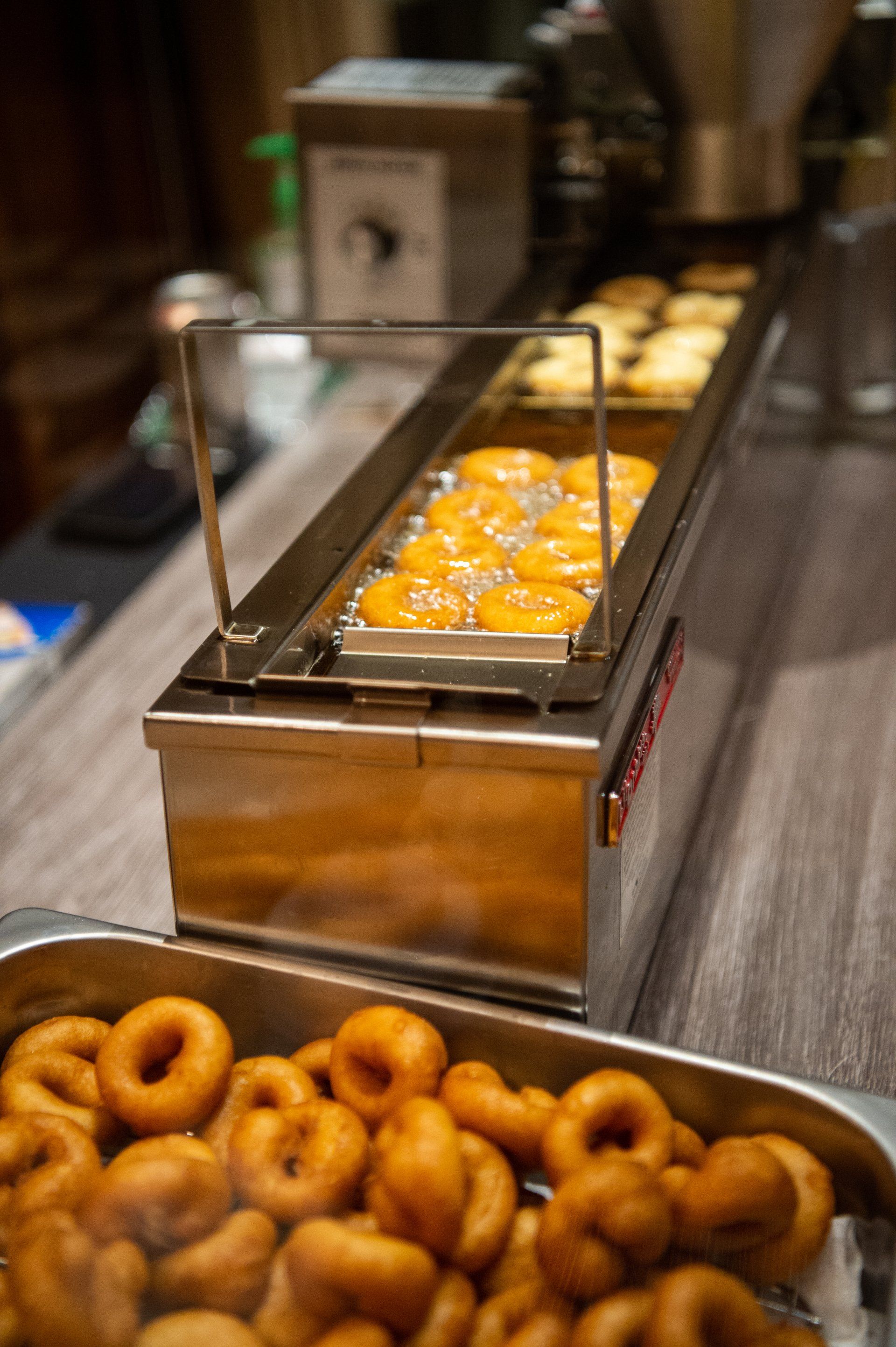 A tray of donuts sitting on top of a table next to a machine.