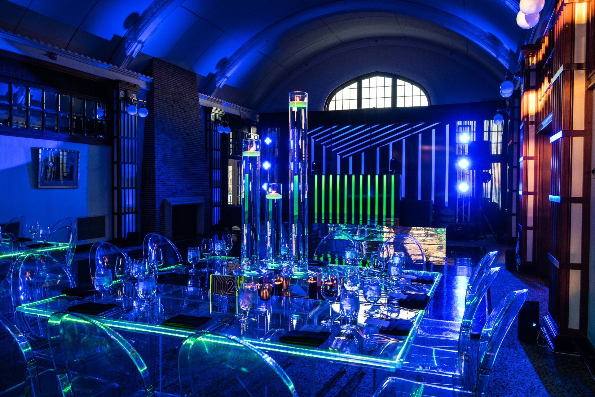 A large room with tables and chairs lit up with blue lights