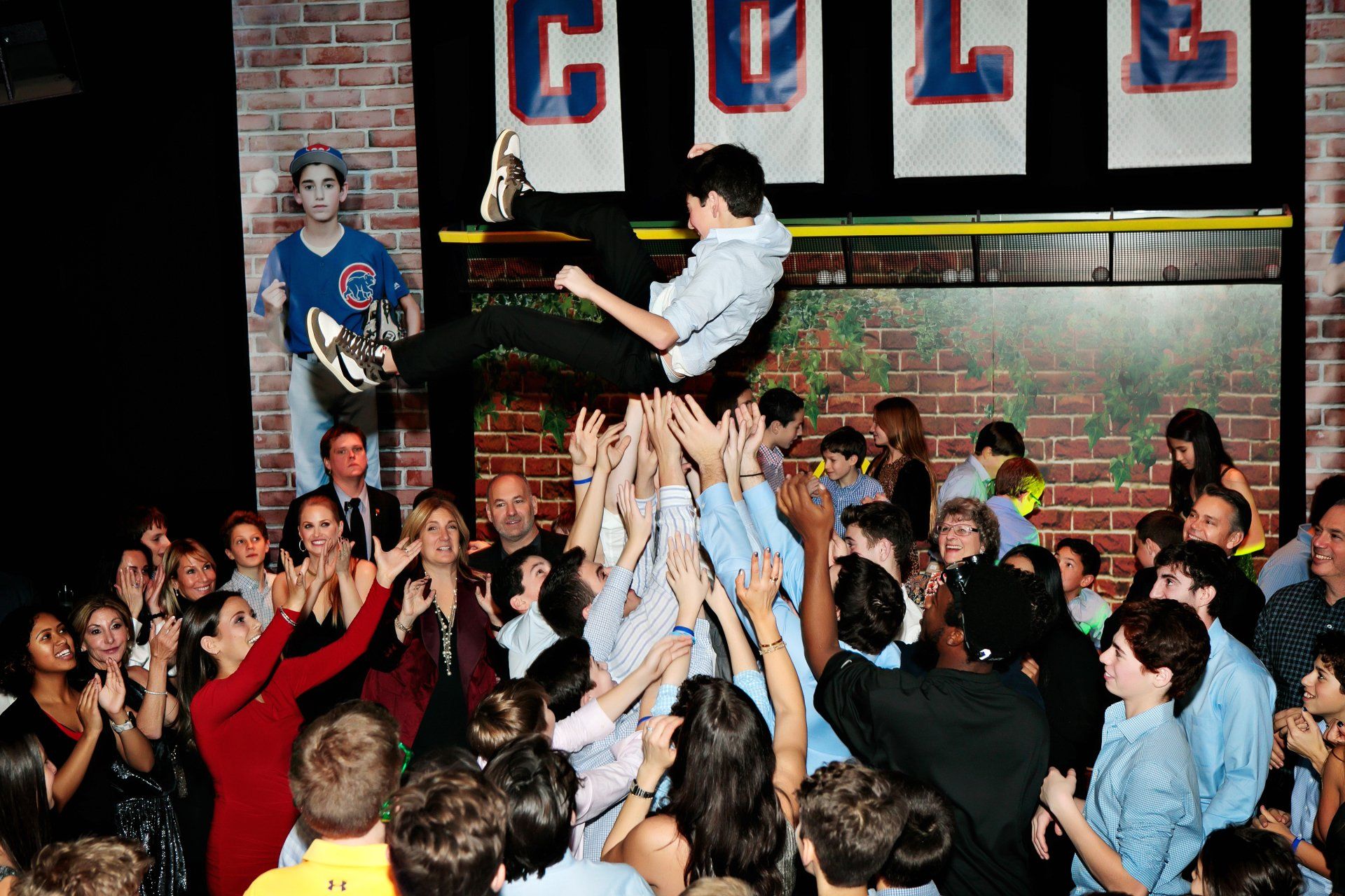A boy is being lifted in the air by a crowd of people