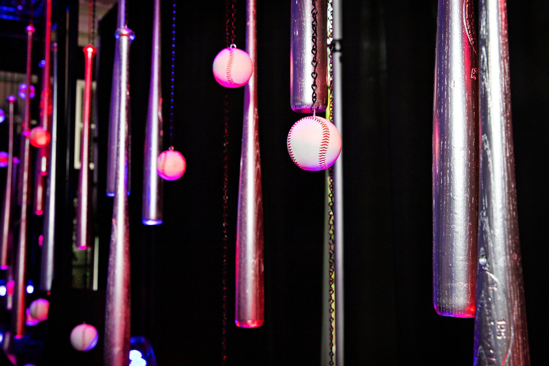 A bunch of baseball bats hanging from the ceiling