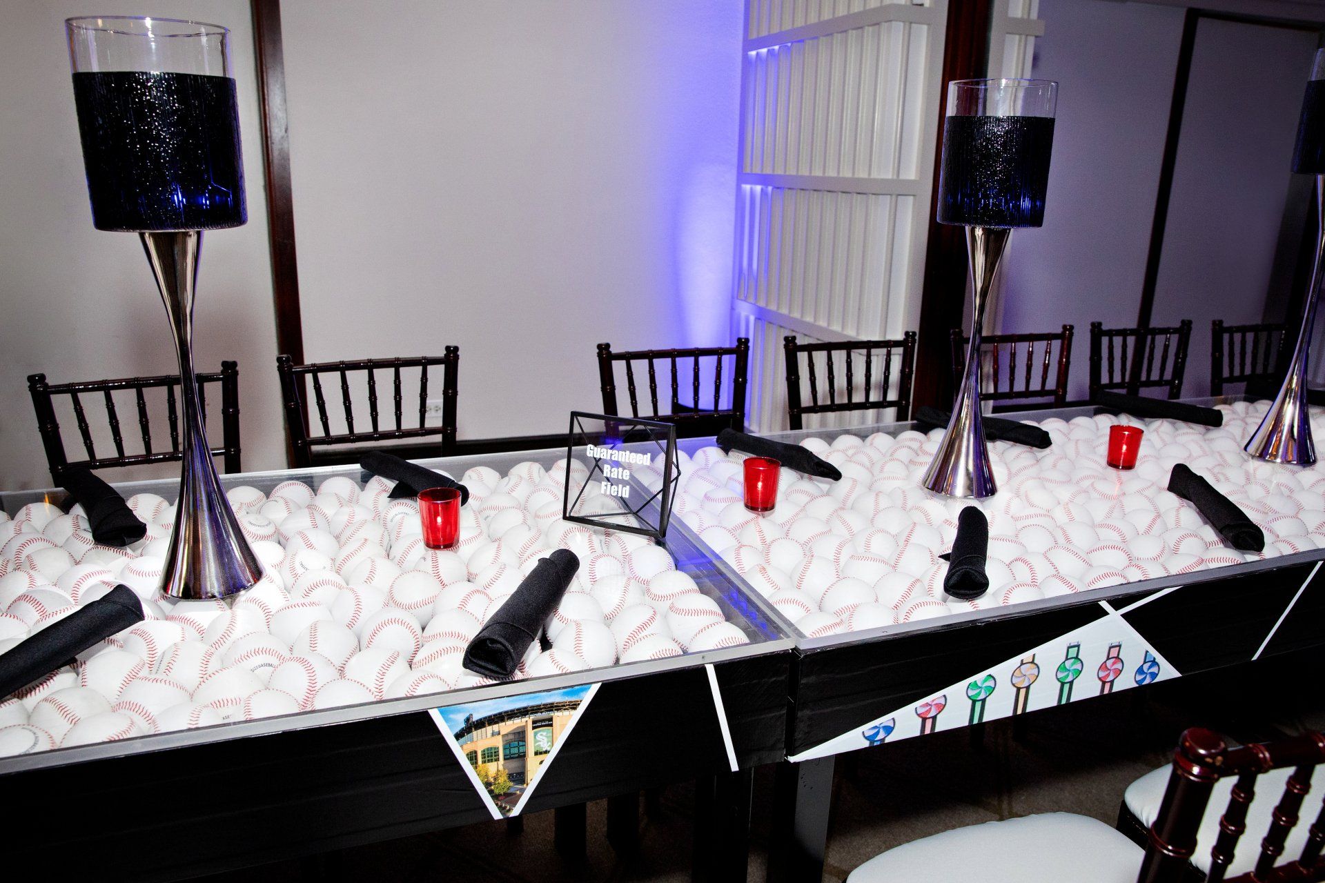 A long table with a bunch of baseballs on it