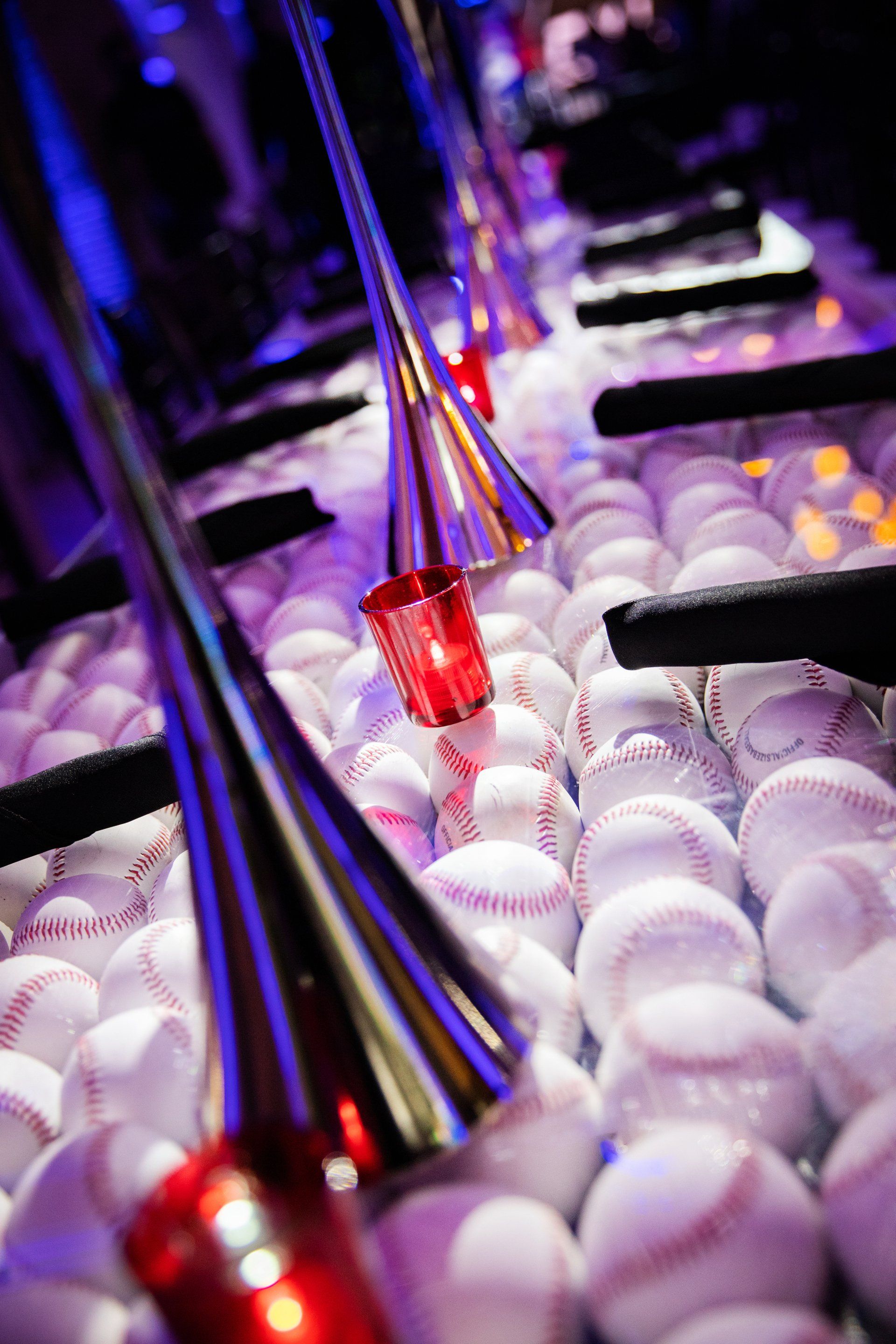 A bunch of baseballs and candles on a table.