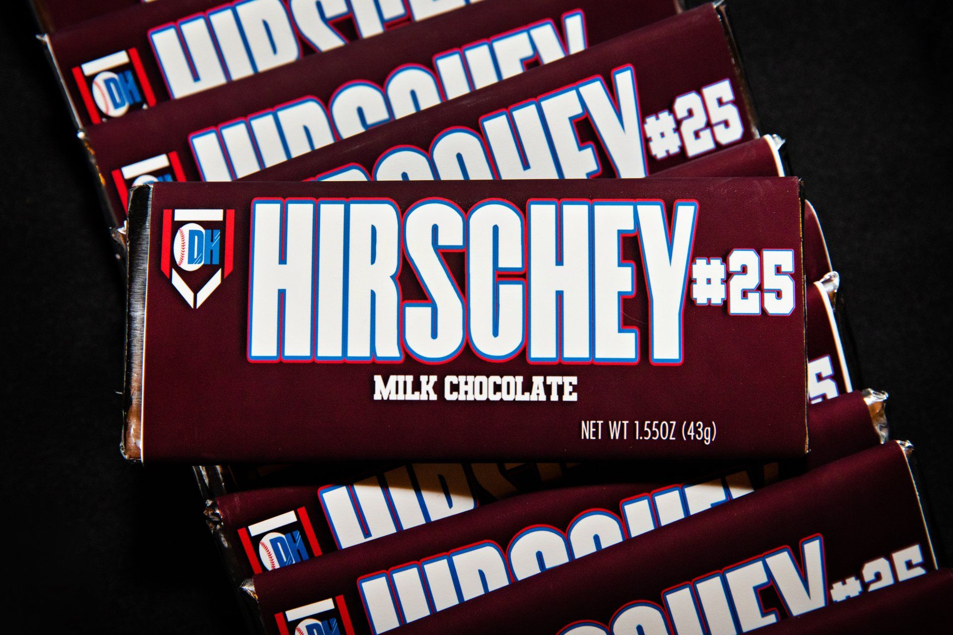 A stack of hershey milk chocolate bars on a black background