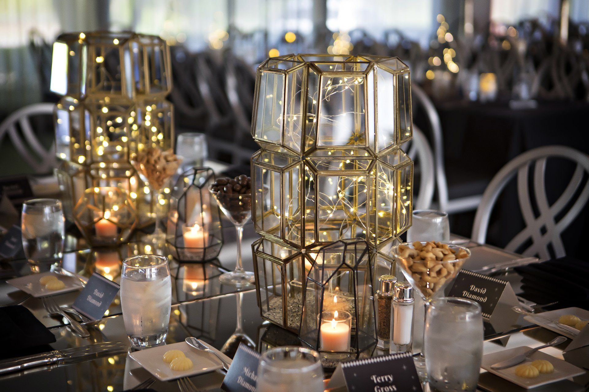 A table set for a party with candles and glasses on it.