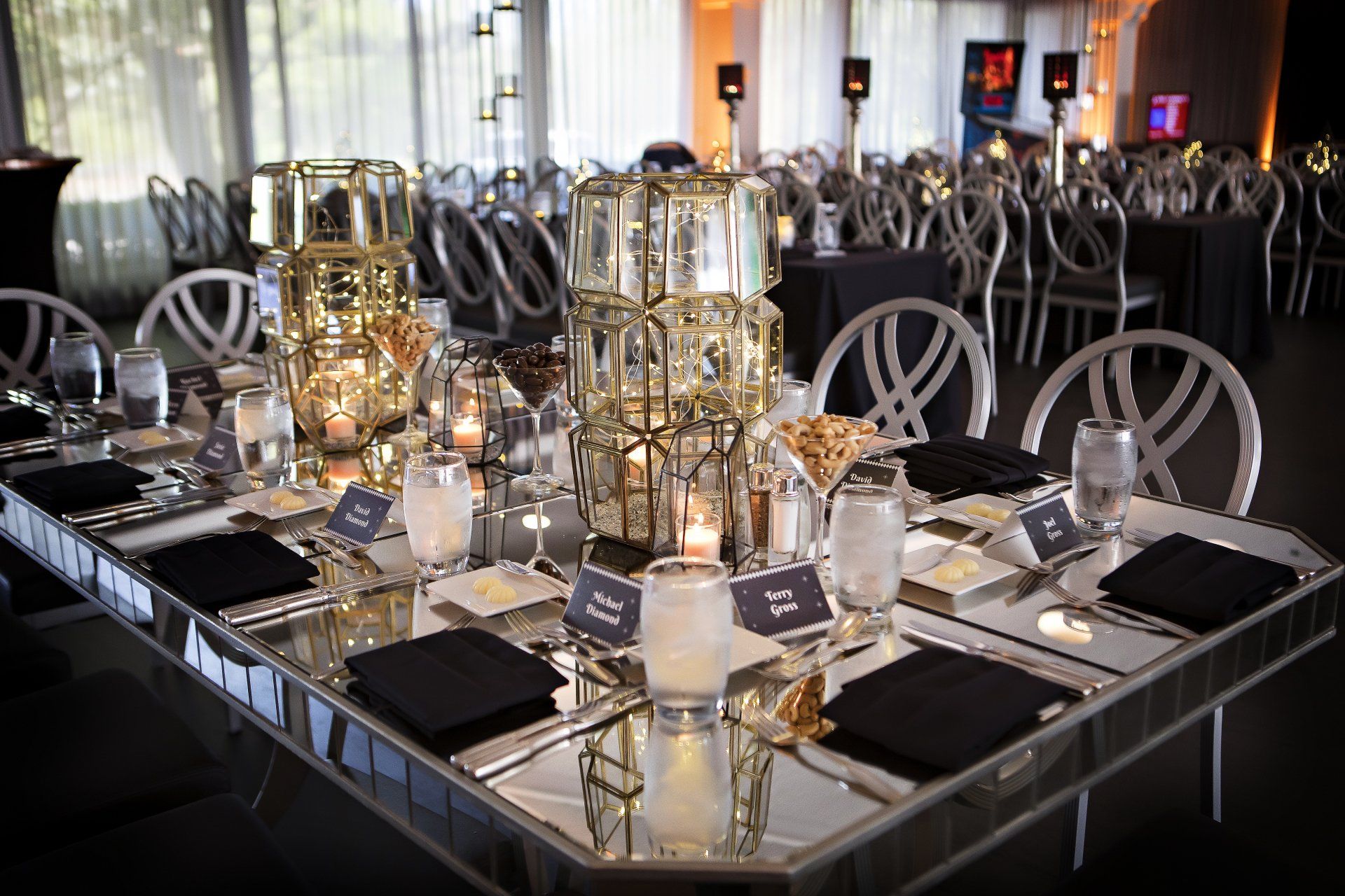 A table set for a wedding reception with candles and glasses on it.