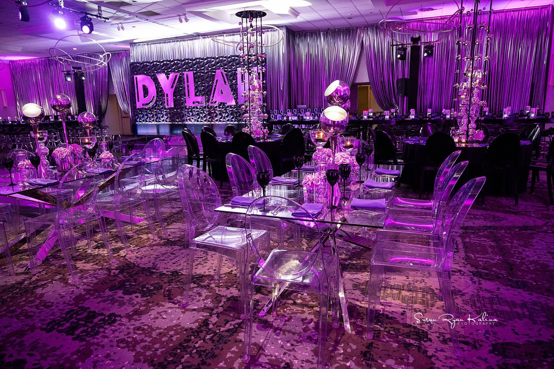 A large room filled with tables and chairs and purple lights.
