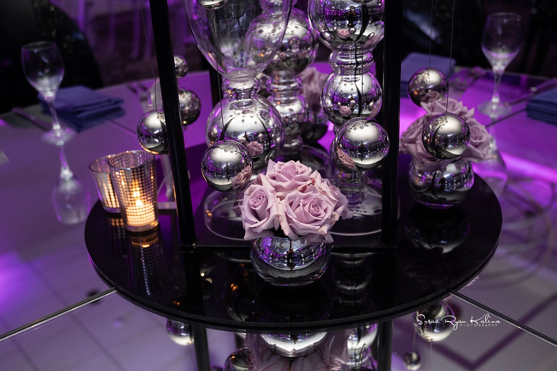 A table with a vase of flowers and candles on it.