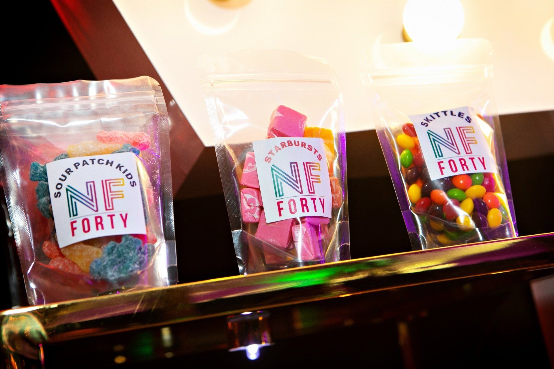 Three bags of candy are lined up on a shelf.