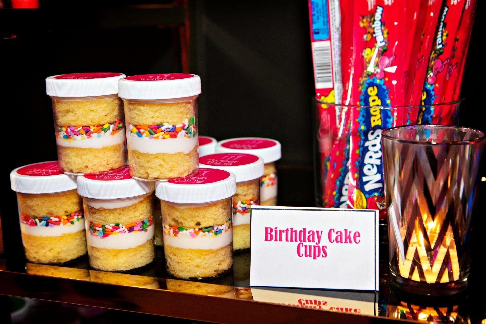 A display of birthday cake cups with a sign that says birthday cake cups.