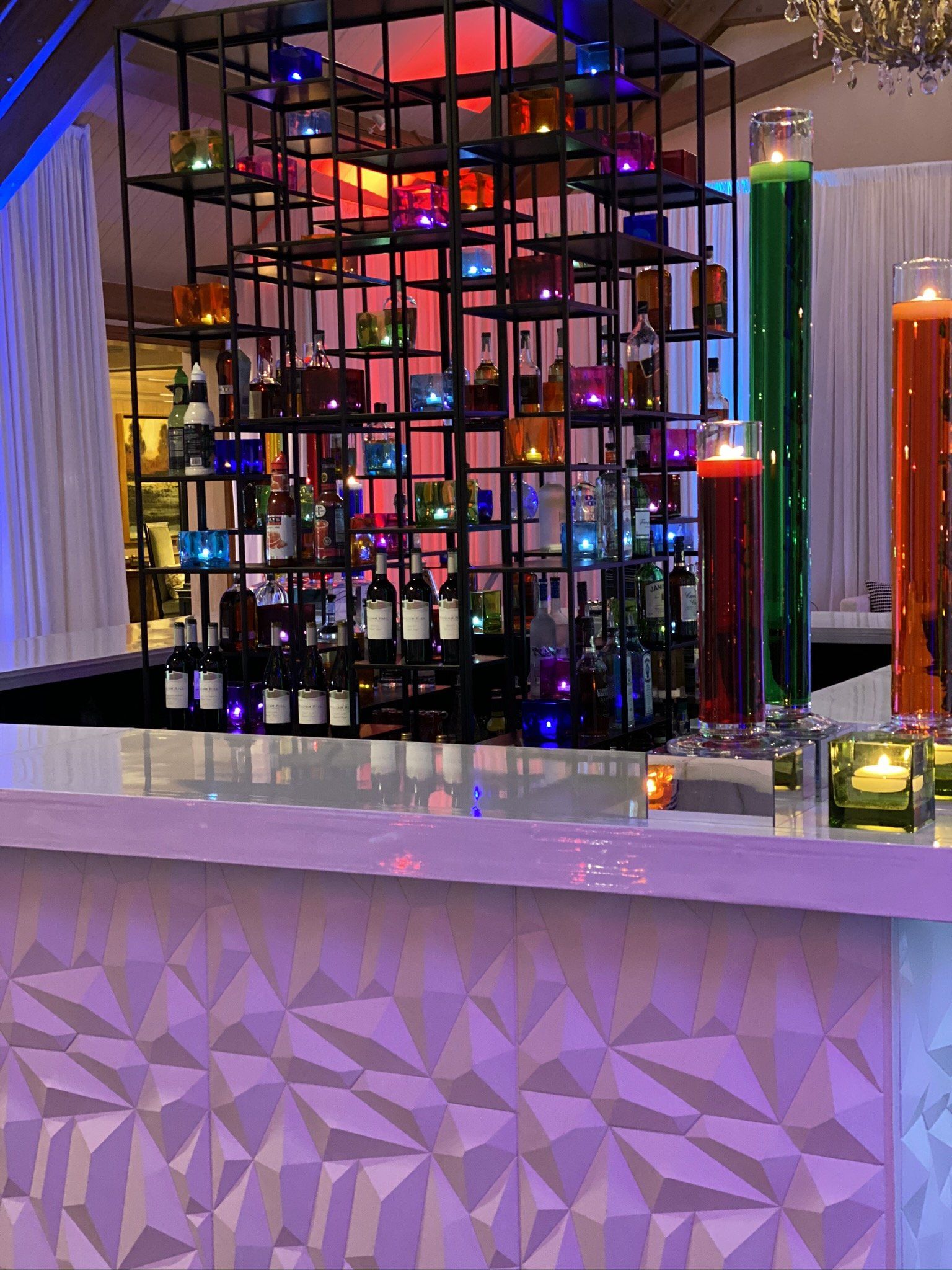 A bar with a lot of bottles and candles on it