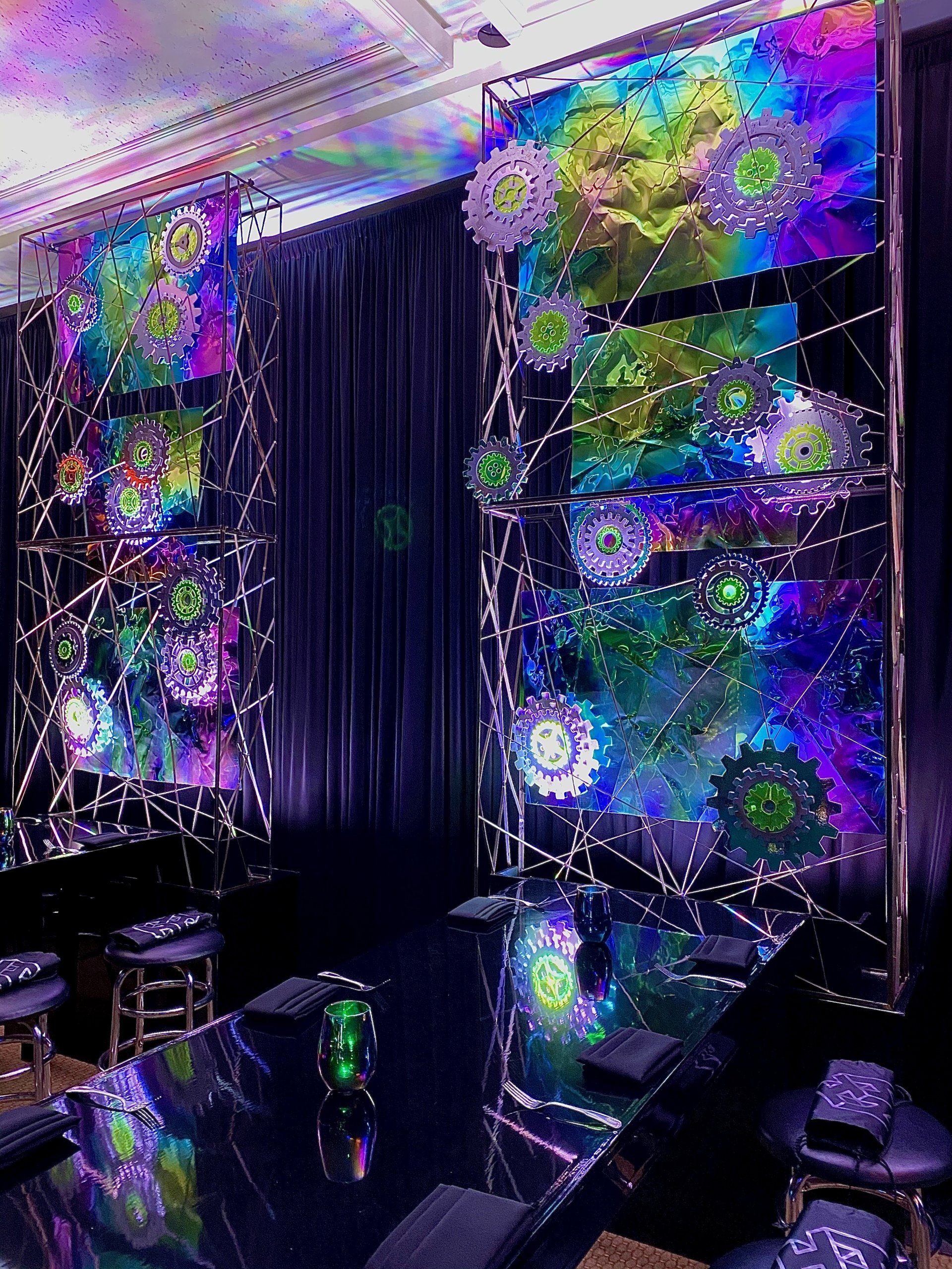 A room with a painting on the wall and a table and chairs.