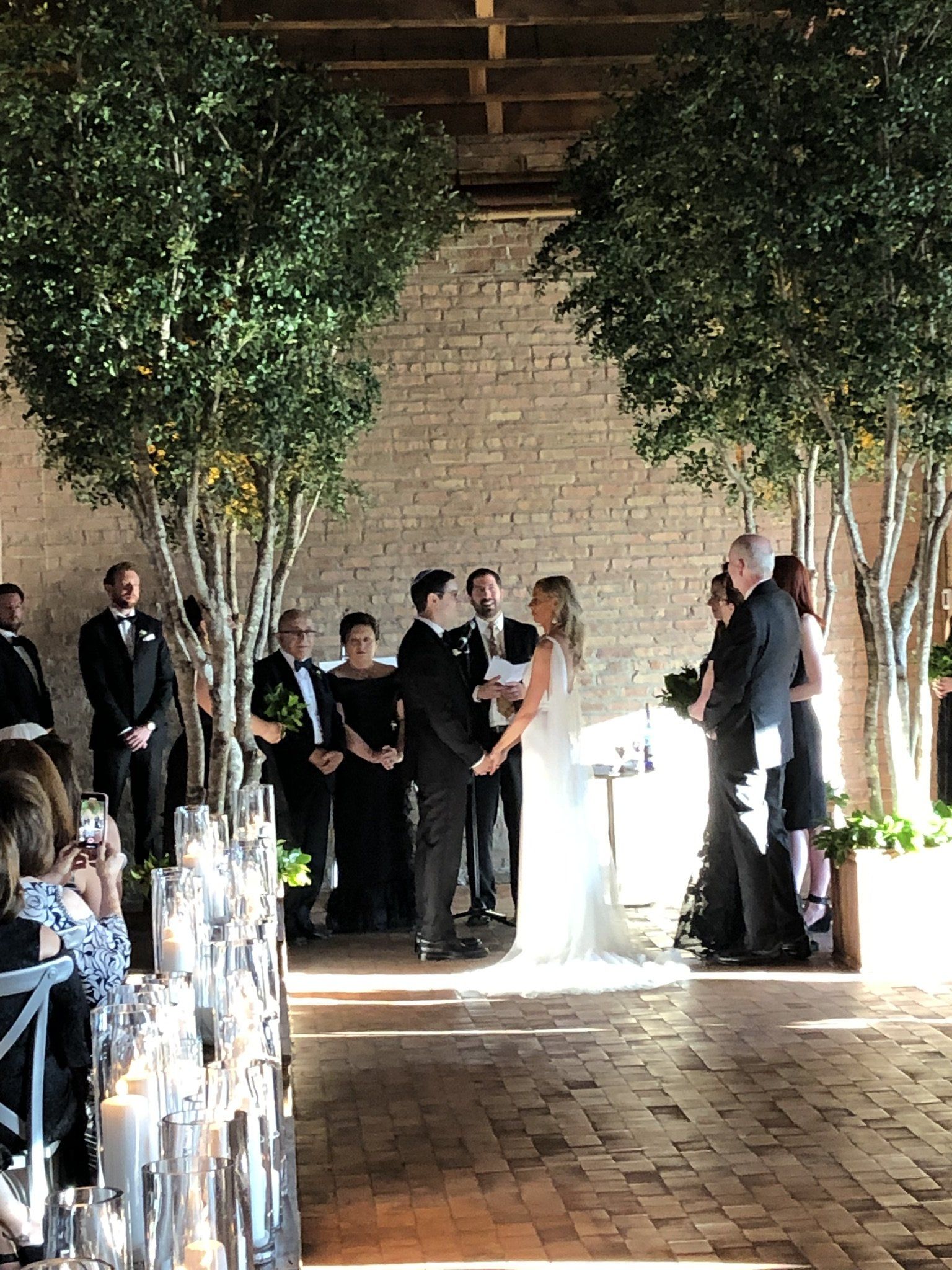 A bride and groom are holding hands during their wedding ceremony.