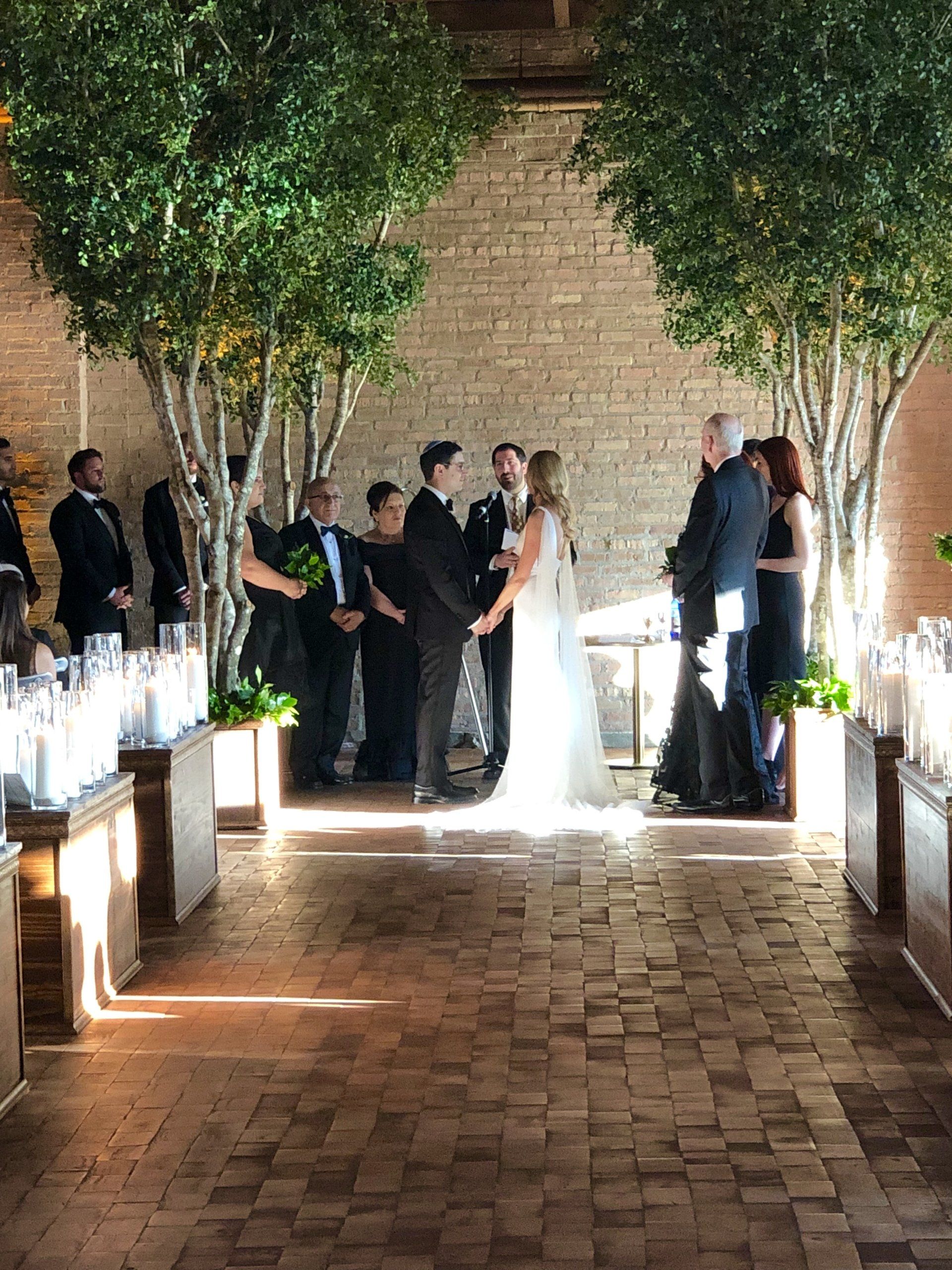 A bride and groom are holding hands during their wedding ceremony.
