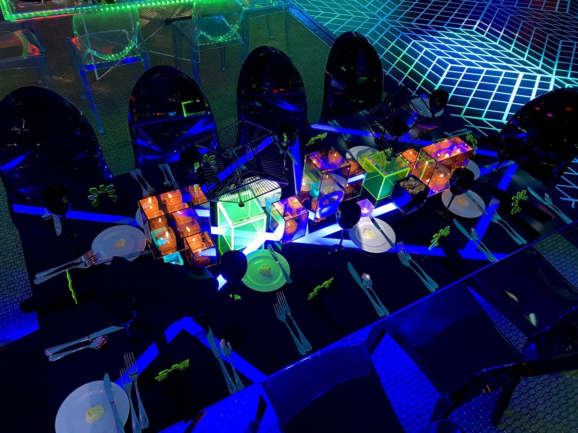A table set up for a party with glow in the dark decorations.