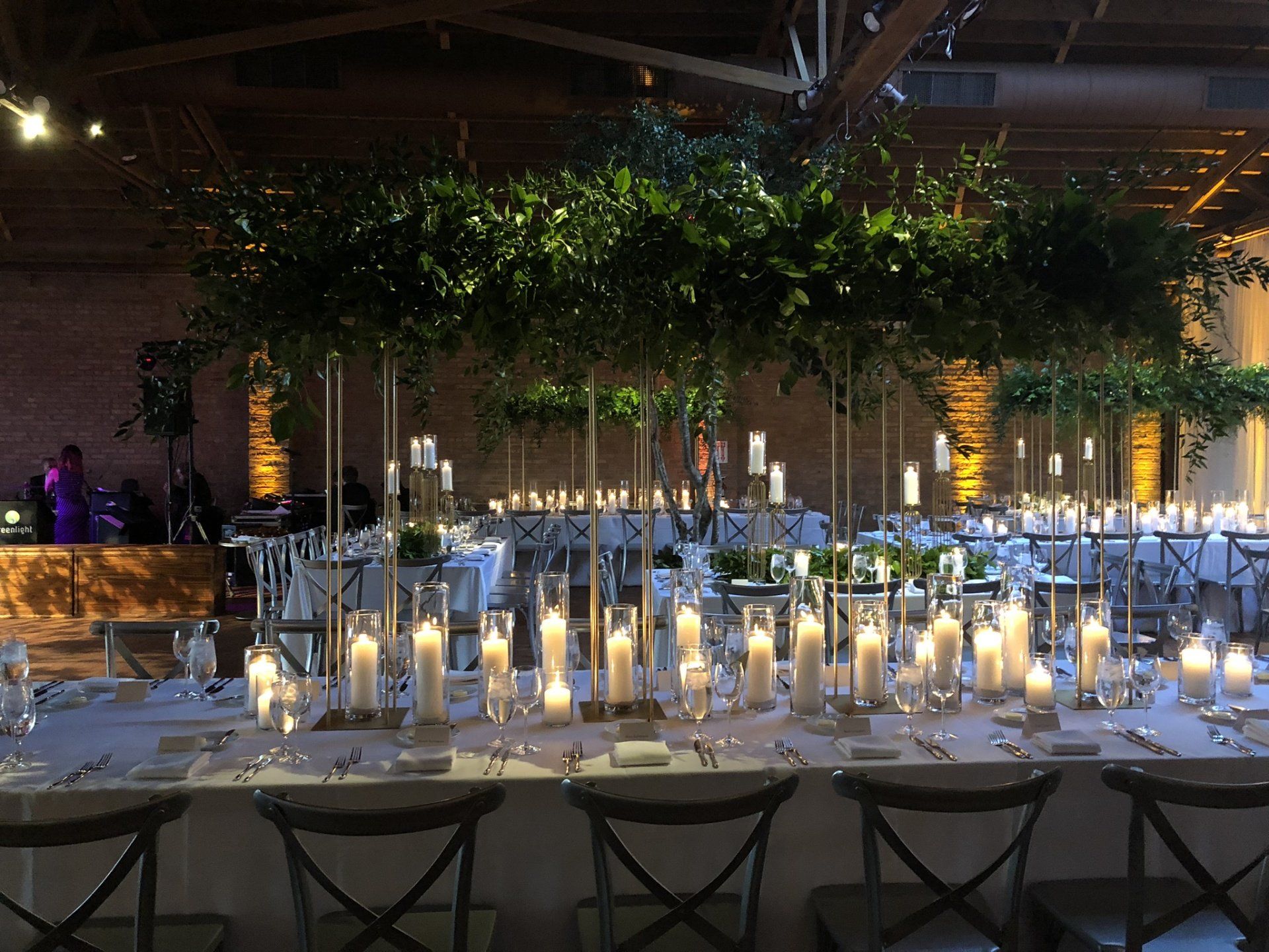 A long table with lots of candles and flowers on it.