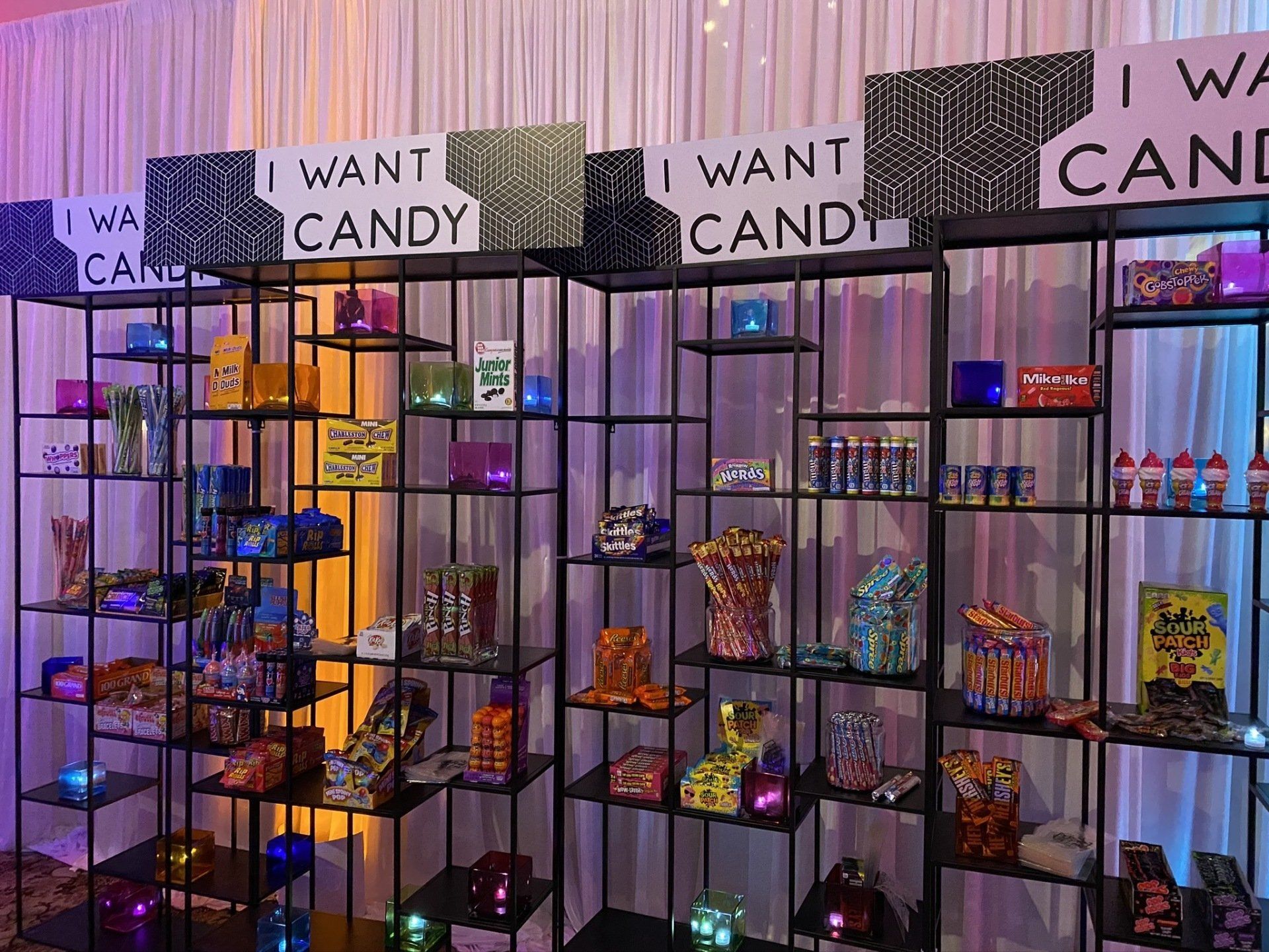 A room filled with shelves filled with candy and signs that say `` i want candy ''.