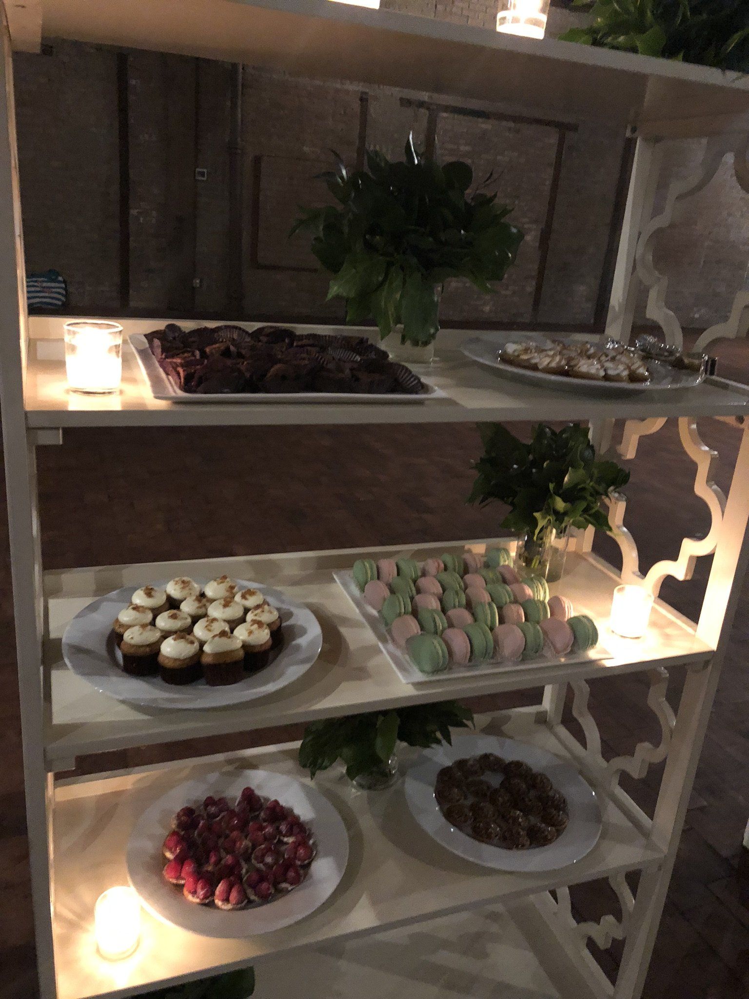 A shelf filled with plates of food and candles.