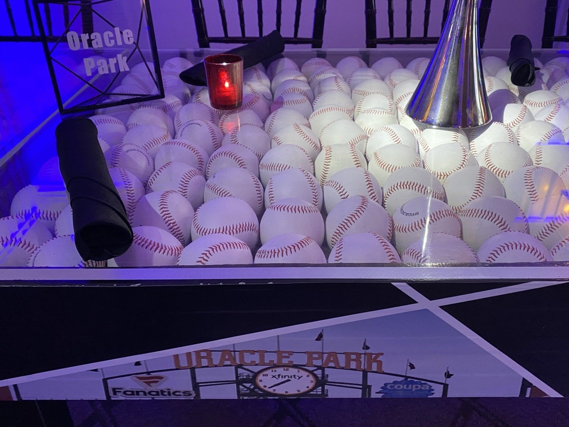A bunch of baseballs are sitting on top of a table.