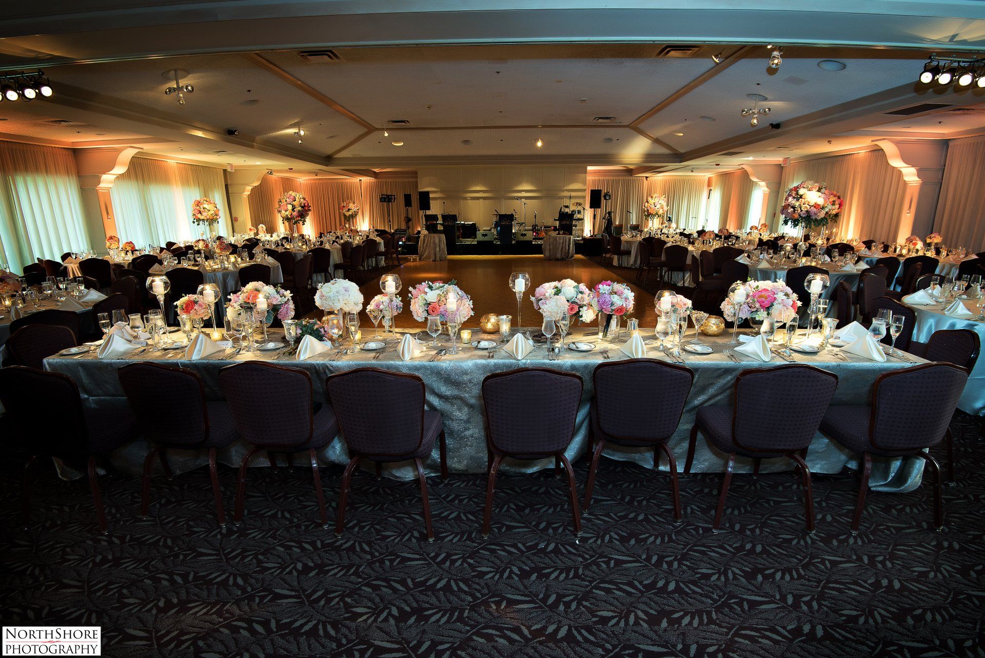 A large room with tables and chairs set up for a wedding reception.