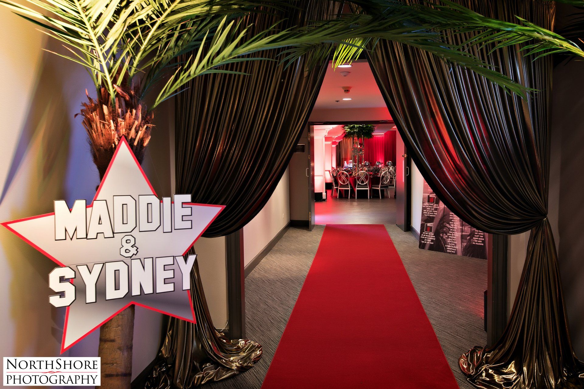 A hallway with a red carpet and a sign that says maddie and sydney