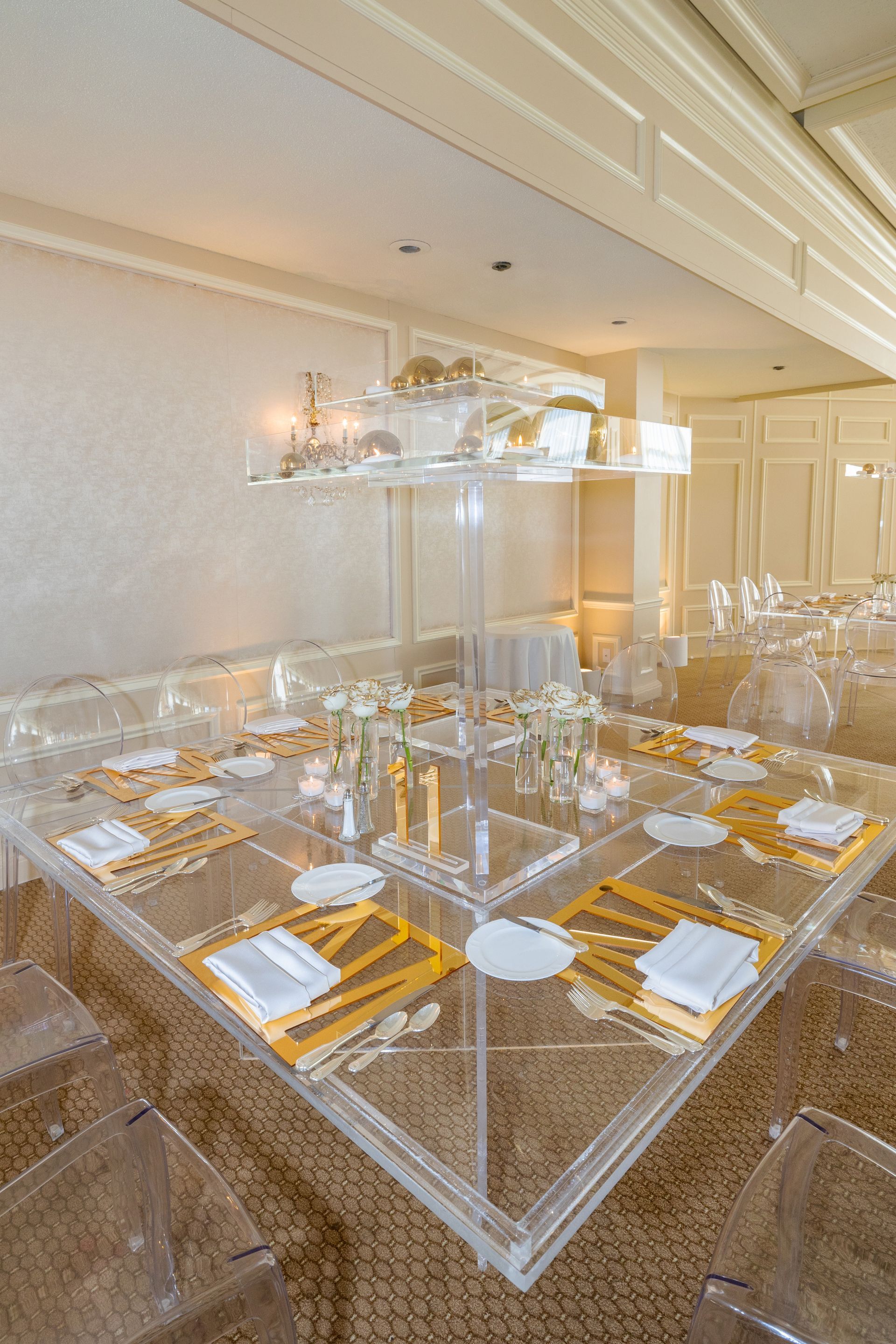 A clear acrylic table set for a wedding reception.