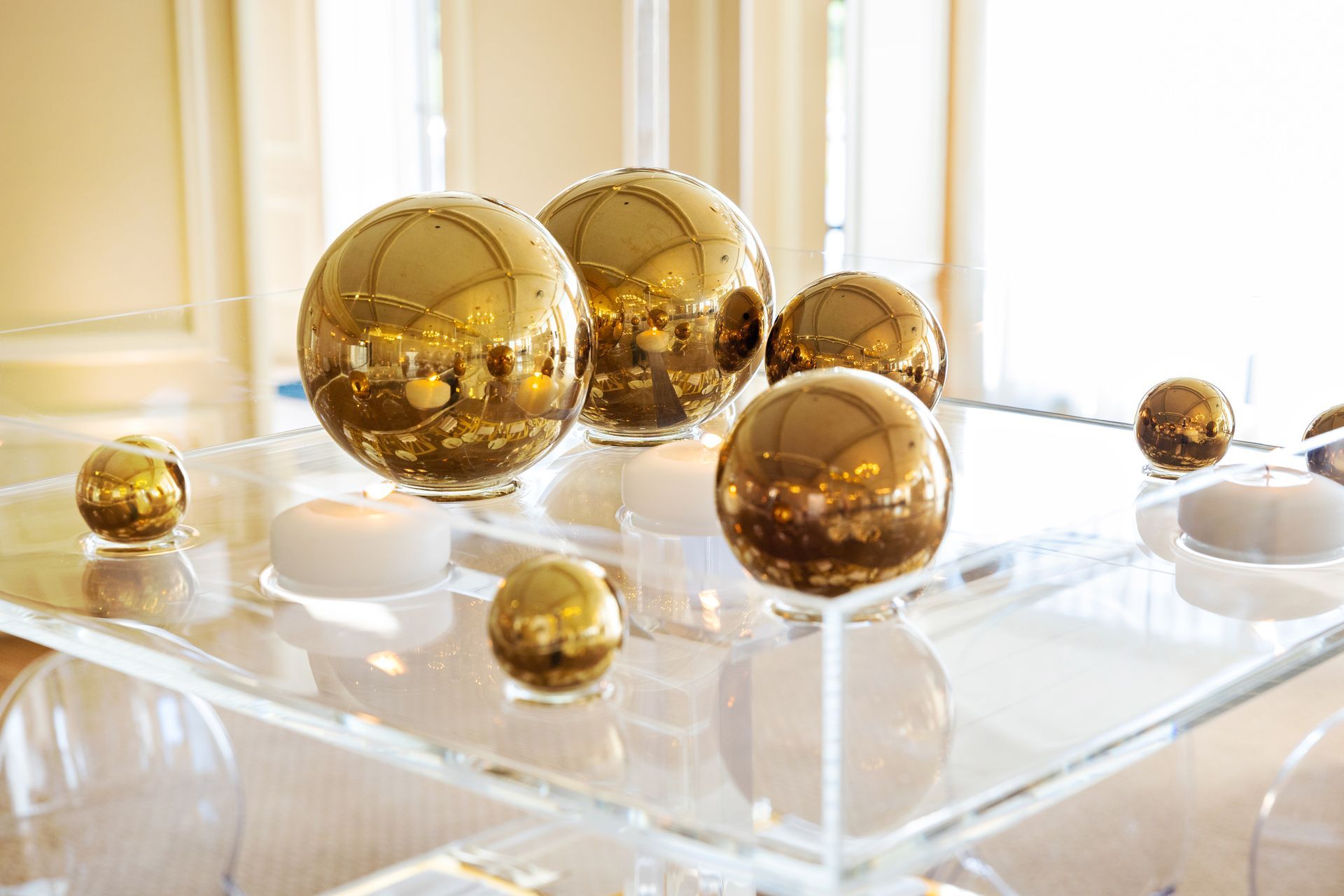 A group of gold balls are sitting on top of a clear tray.