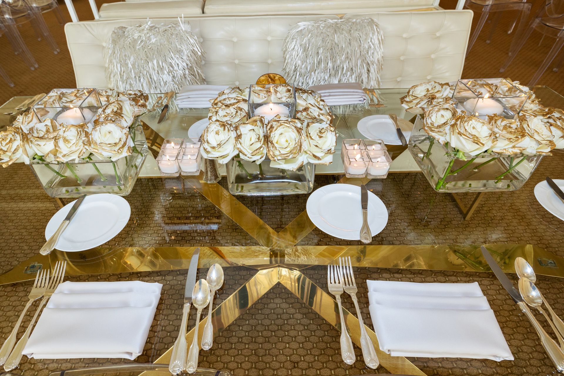 A table with plates , silverware , candles and flowers on it.