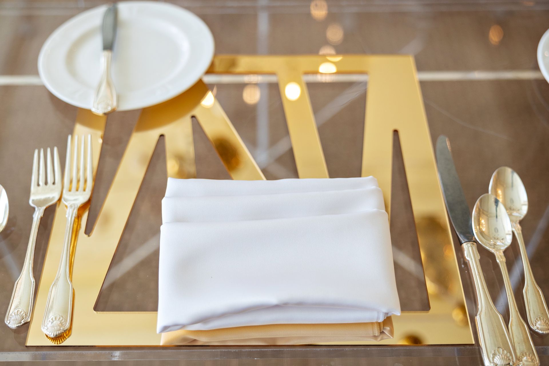 A table with plates , silverware and a napkin on it