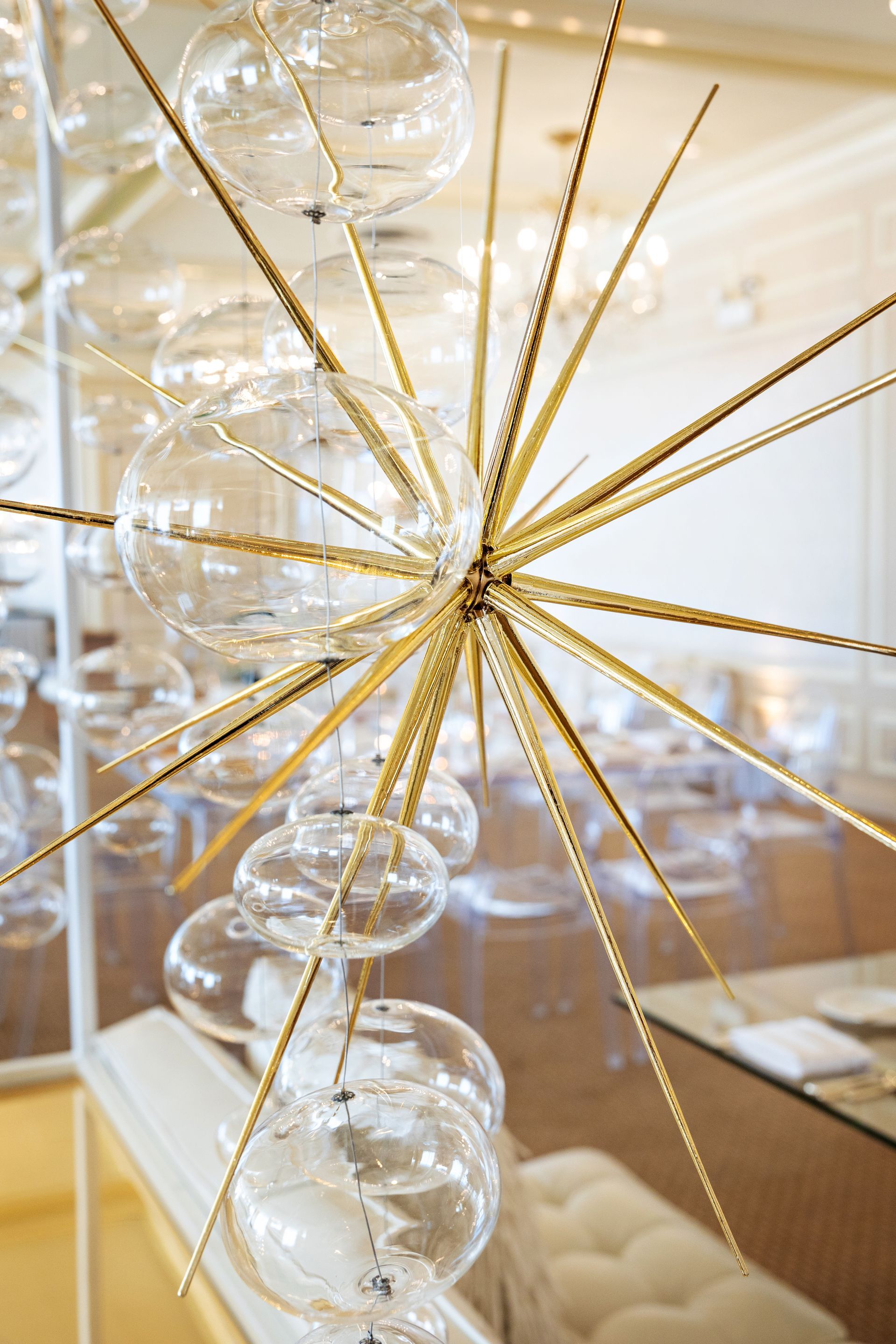 A close up of a star shaped chandelier with clear glass balls hanging from the ceiling.