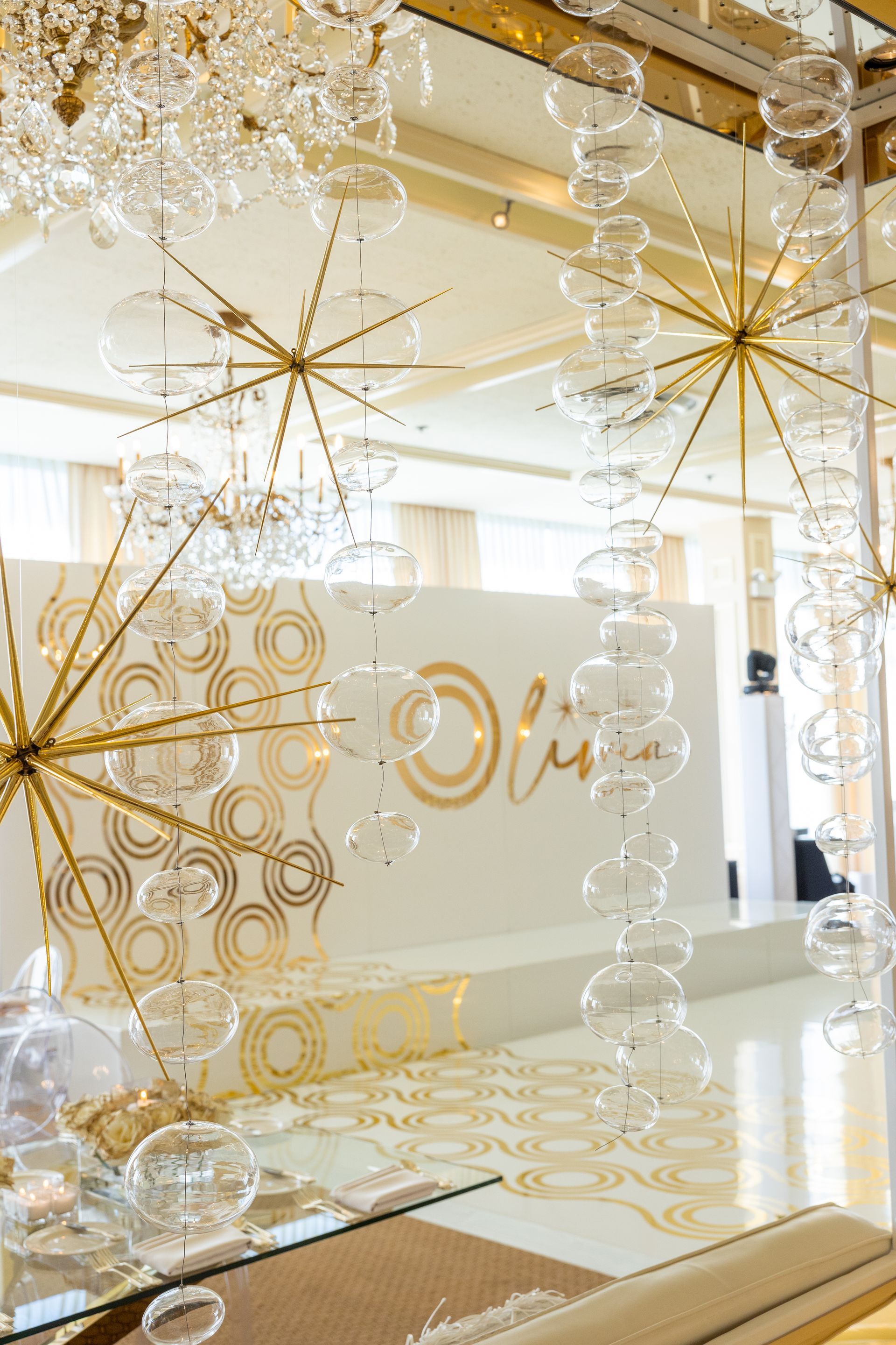 A room with a mirror and a chandelier hanging from the ceiling.