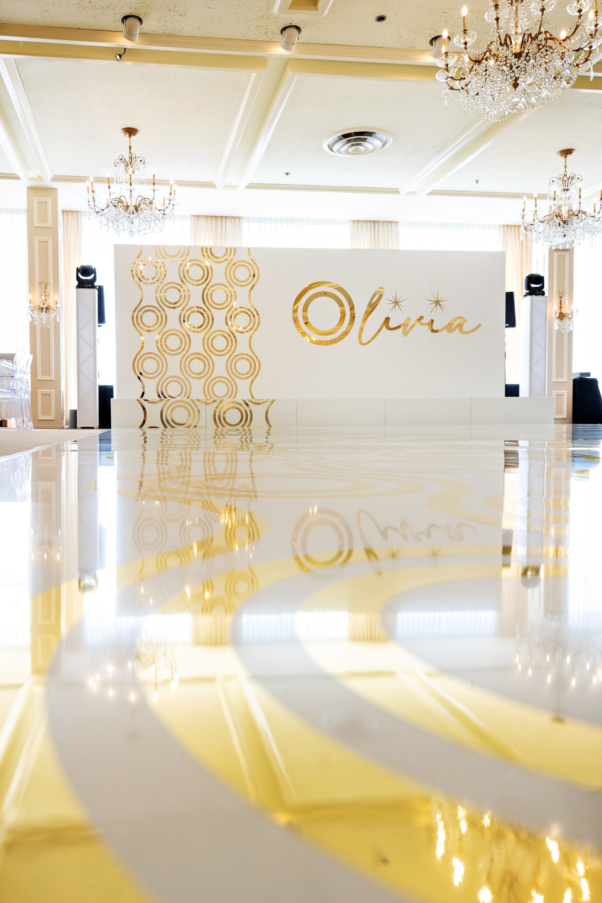 A large room with a white wall and a dance floor.