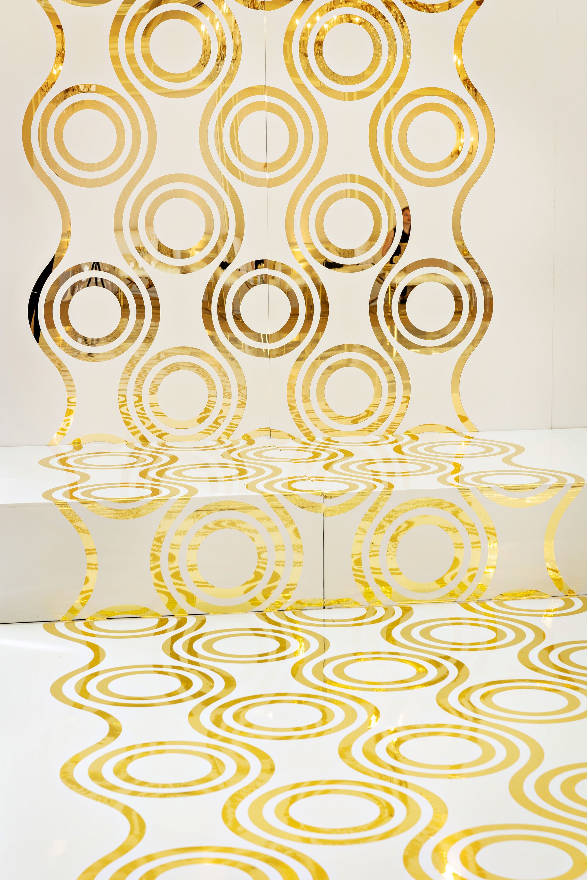 A white wall with gold circles on it