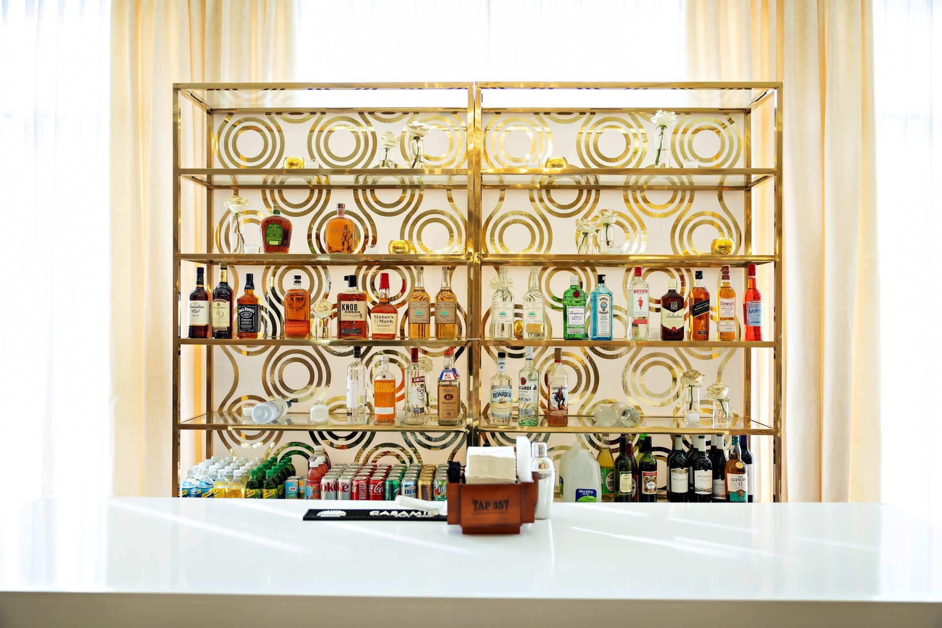 A bar with a lot of bottles and glasses on it.