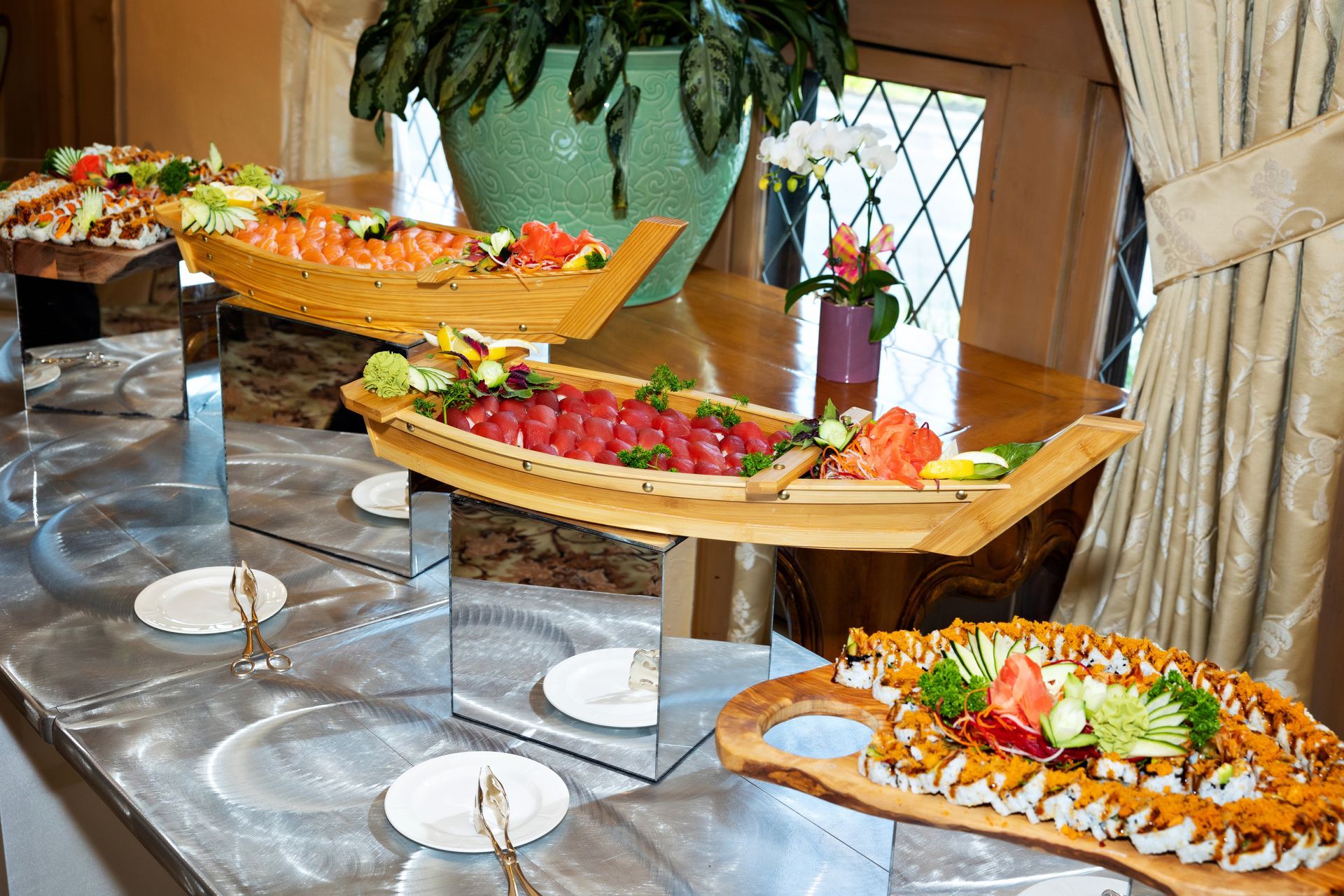 A buffet table with a boat shaped tray filled with food.