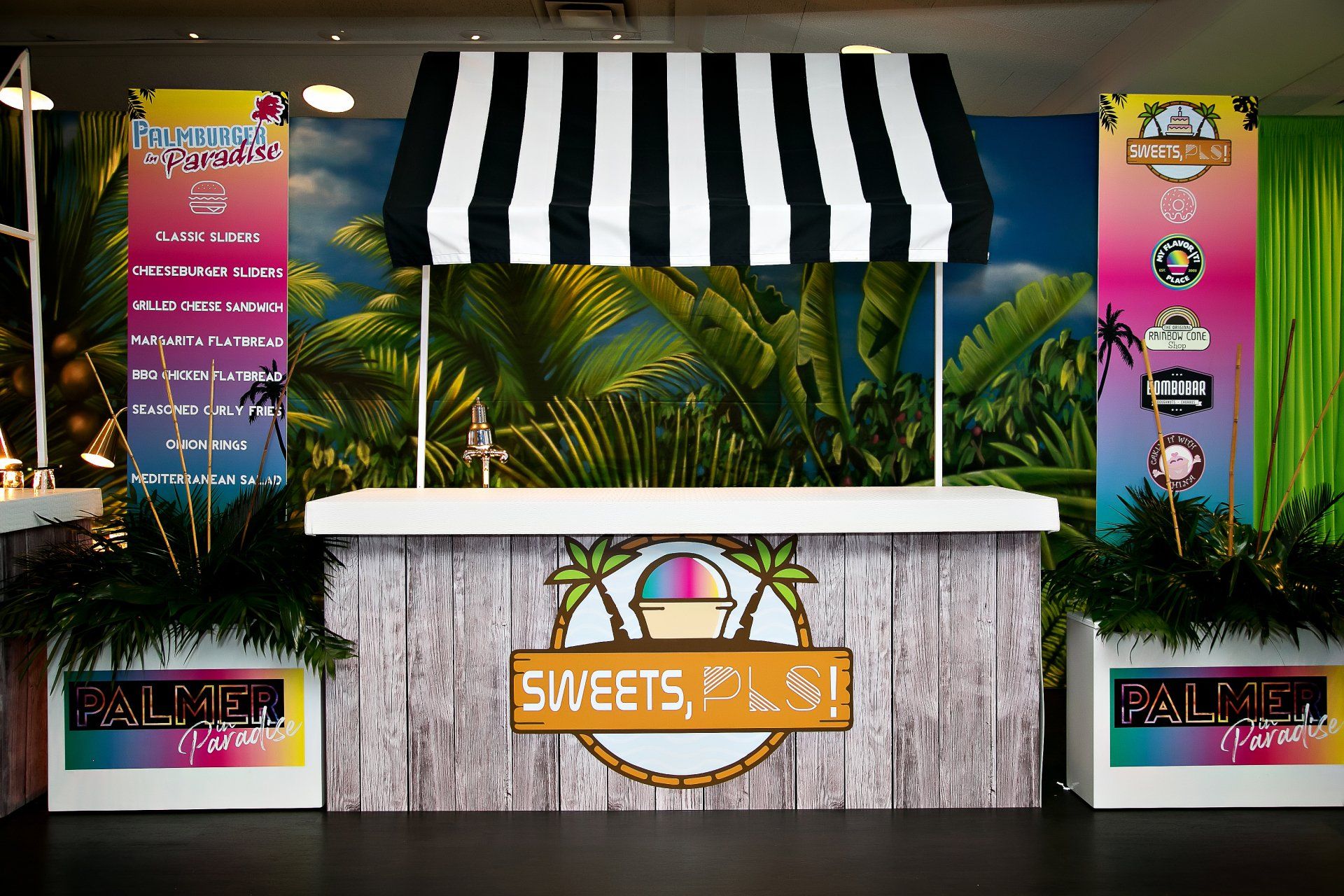 A sweets and ice cream stand with a black and white striped awning.
