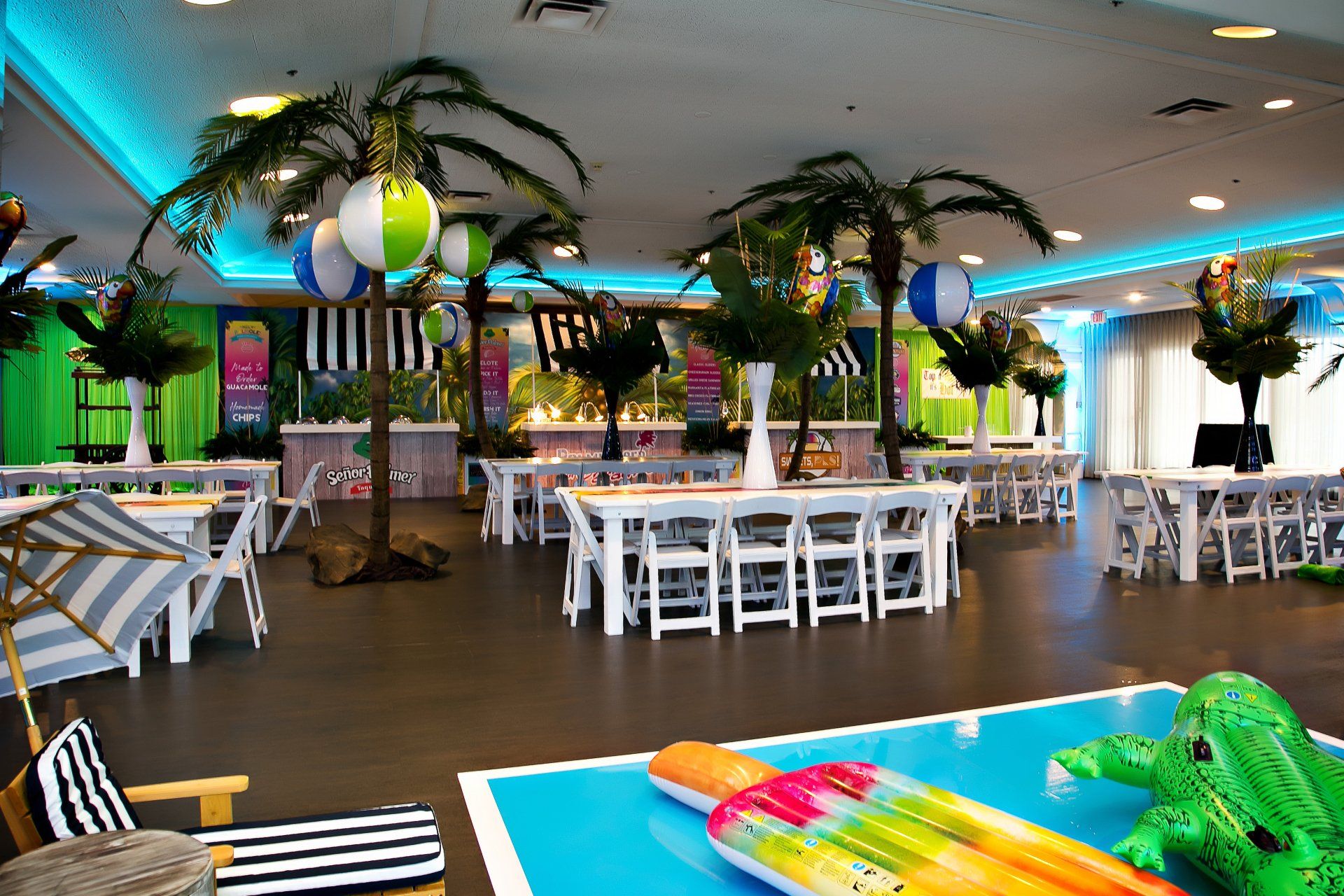 A large room with tables and chairs and a pool.