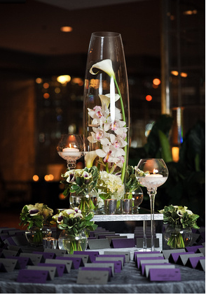 A table with a vase of flowers and candles on it