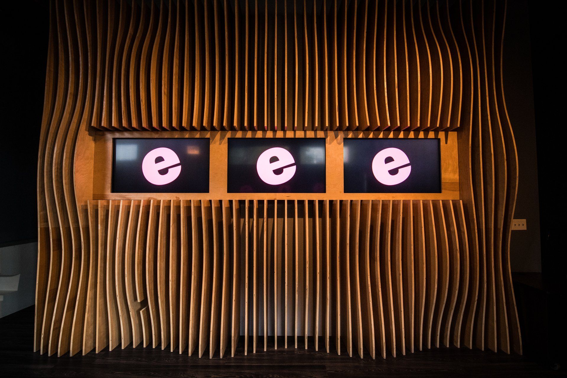 A wooden wall with three screens that say eee