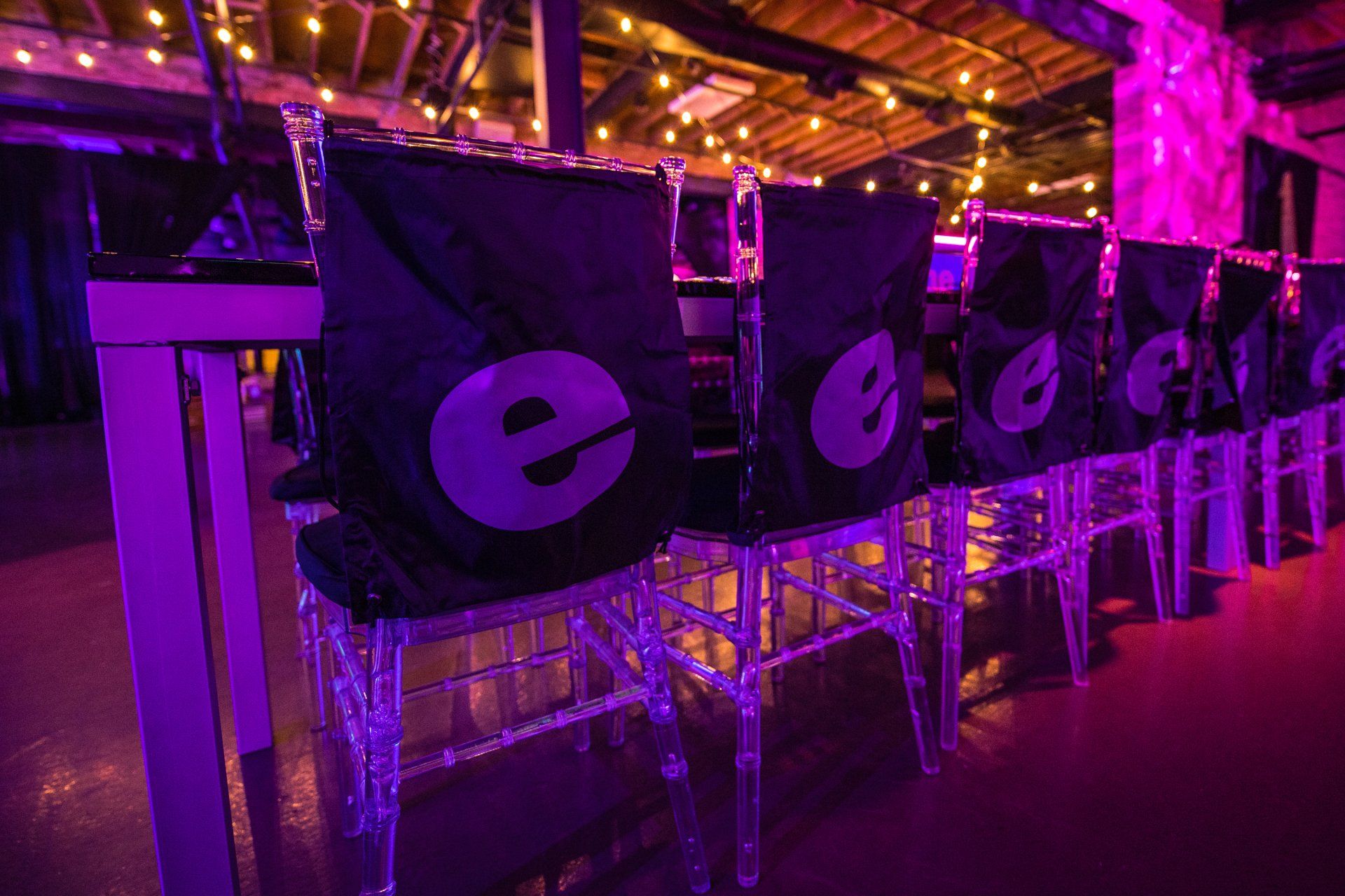 A row of chairs are lined up in a room with purple lights.