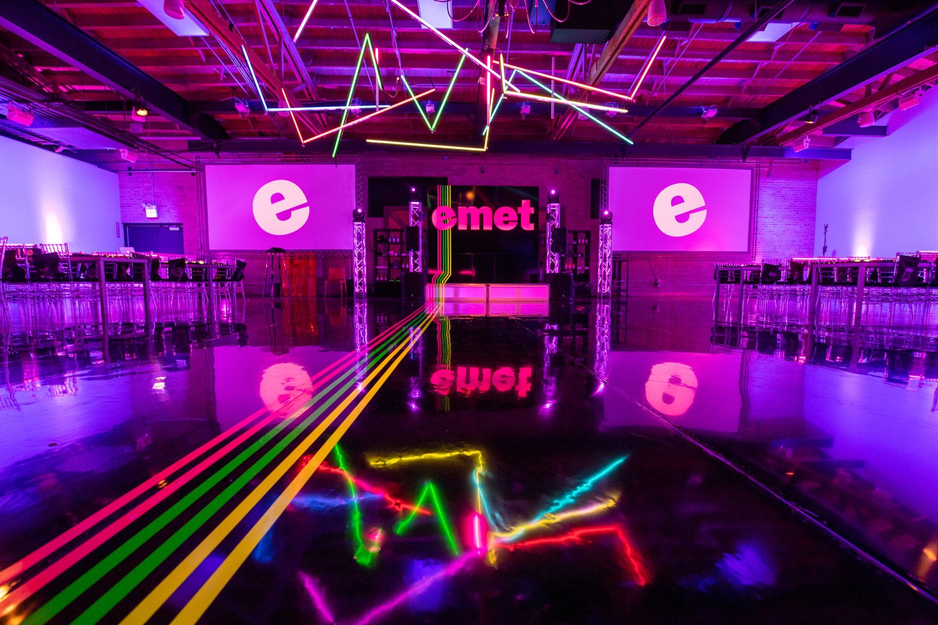 A large room with neon lights and a sign that says comet