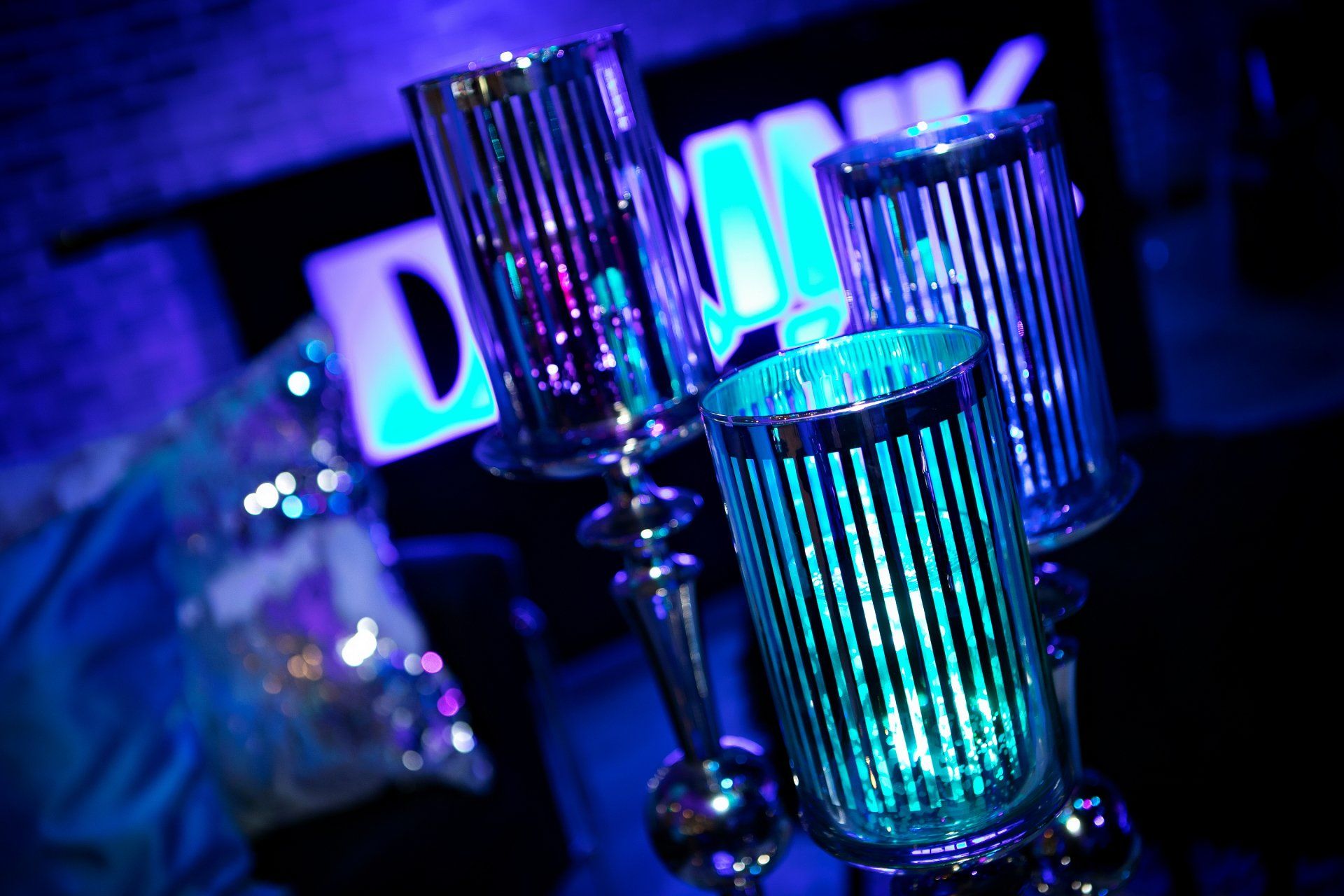 Three candle holders are lit up in a dark room